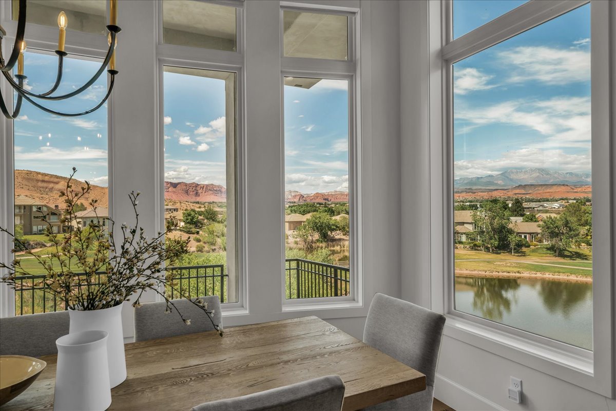 Dining area featuring multiple large windows showcasing a water feature and distant mountains