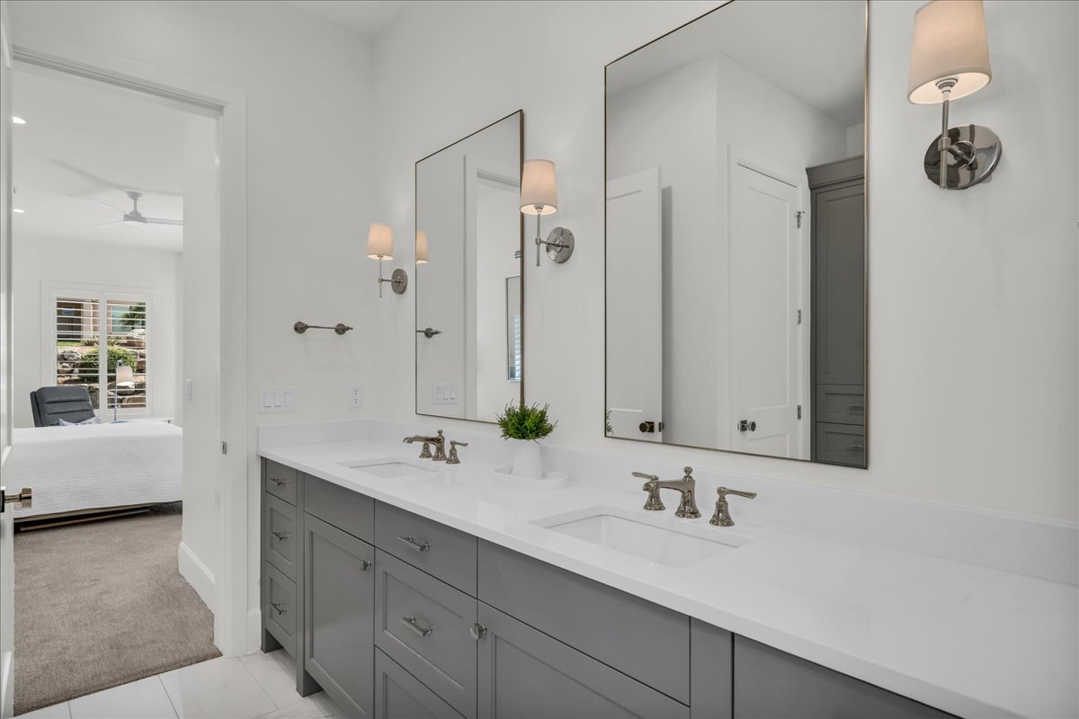 Double vanity featuring a light gray cabinet base and white countertops