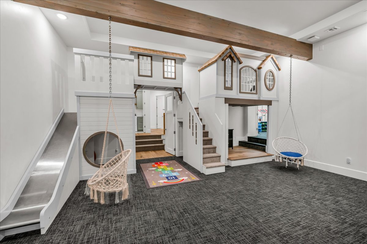 Open playroomroom featuring a built-in play structure with stairs, slide, and miniature architectural elements
