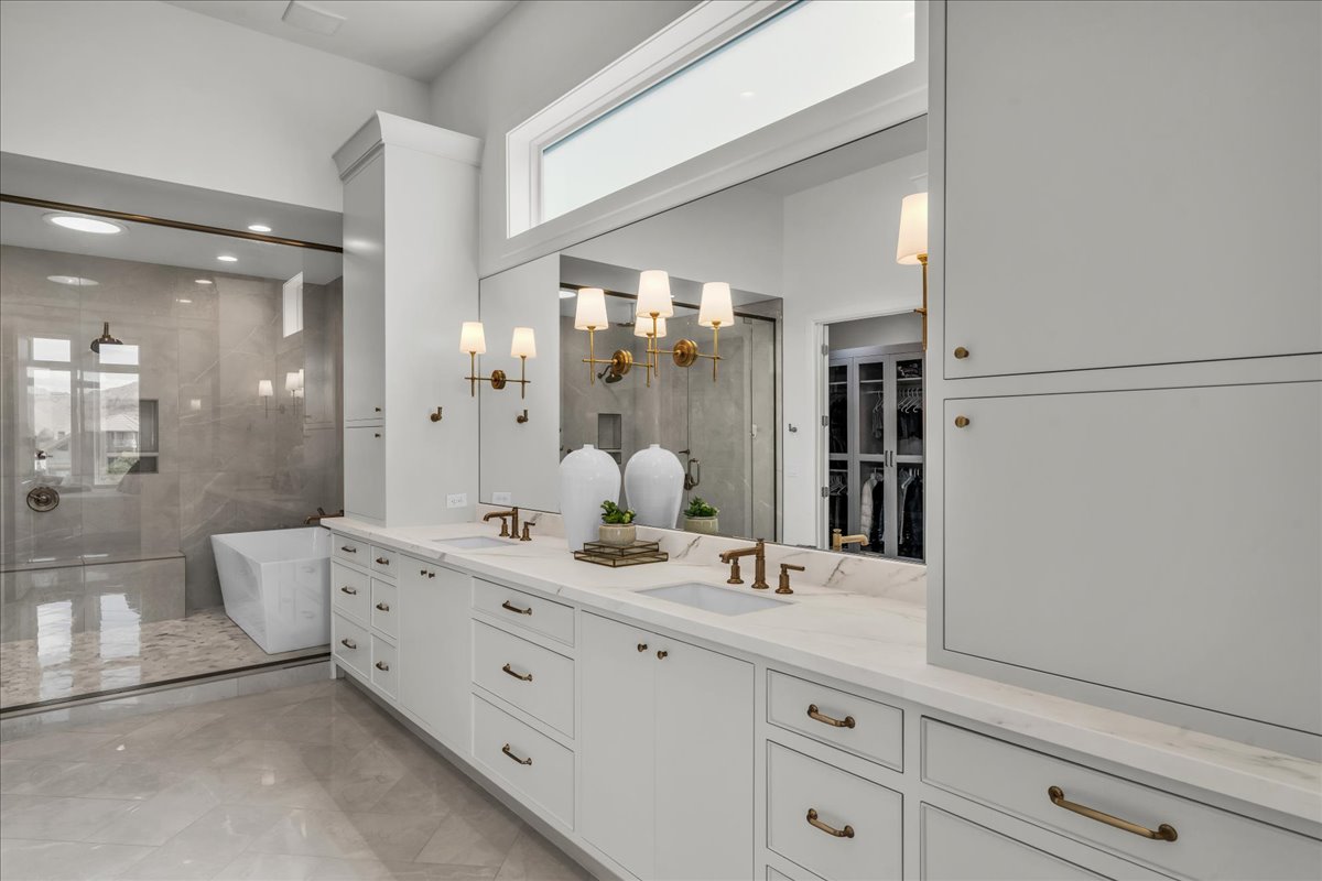 Expansive primary bathroom featuring a double vanity with white cabinetry and light-toned countertops