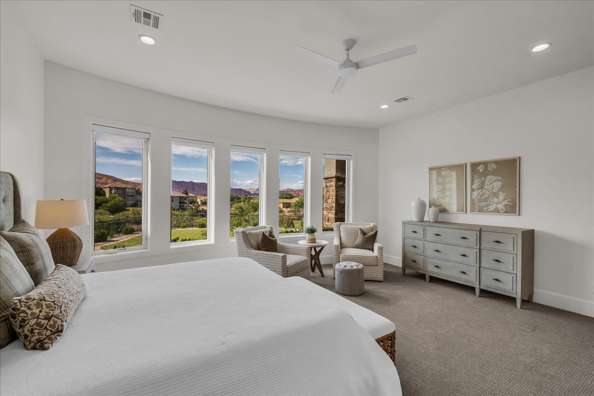 Spacious interior featuring a series of large windows, recessed ceiling lighting, a modern ceiling fan, and light-colored carpeting
