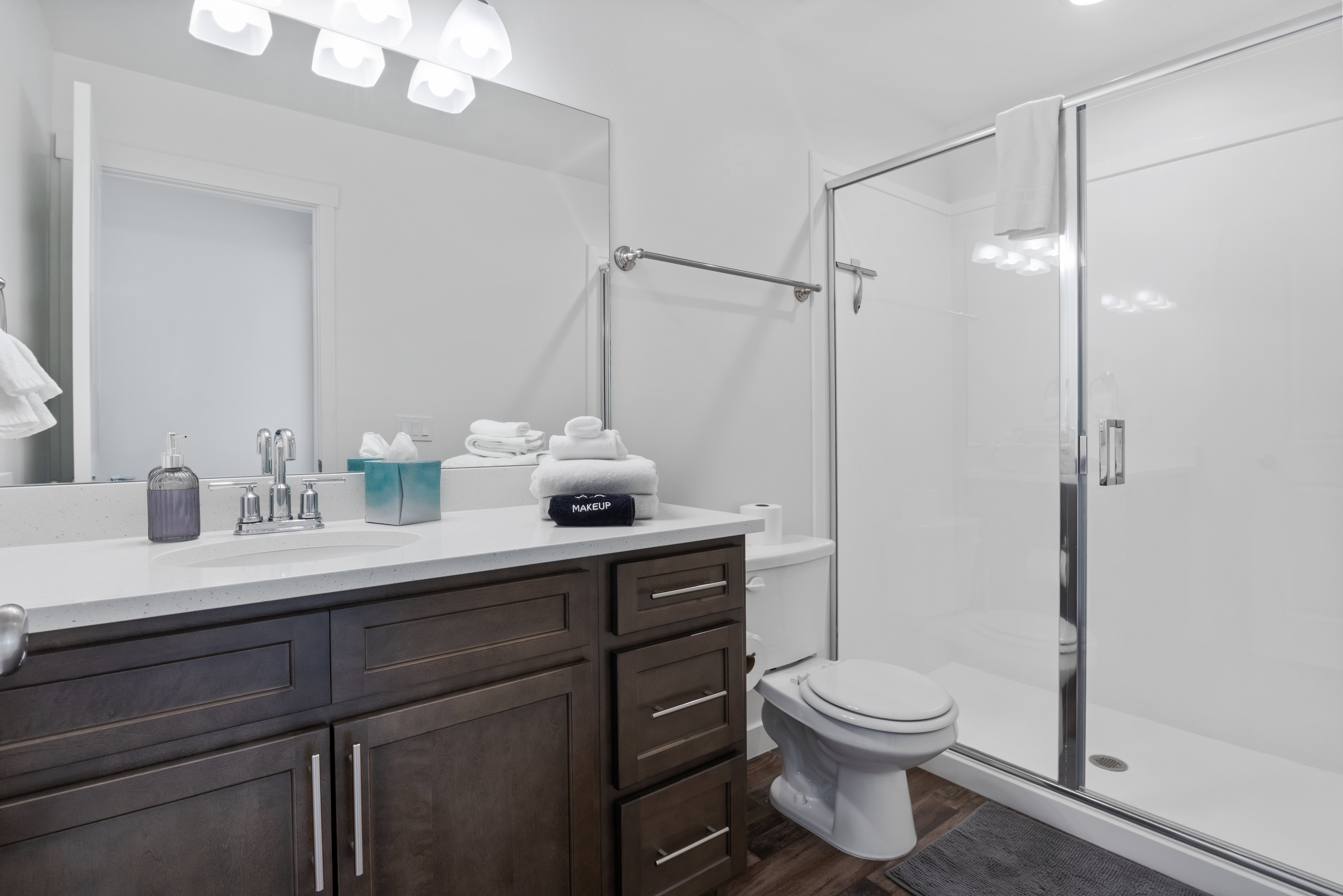 Bathroom featuring a vanity with dark wood-finish cabinetry, a light-toned countertop, and an undermount sink with a chrome faucet