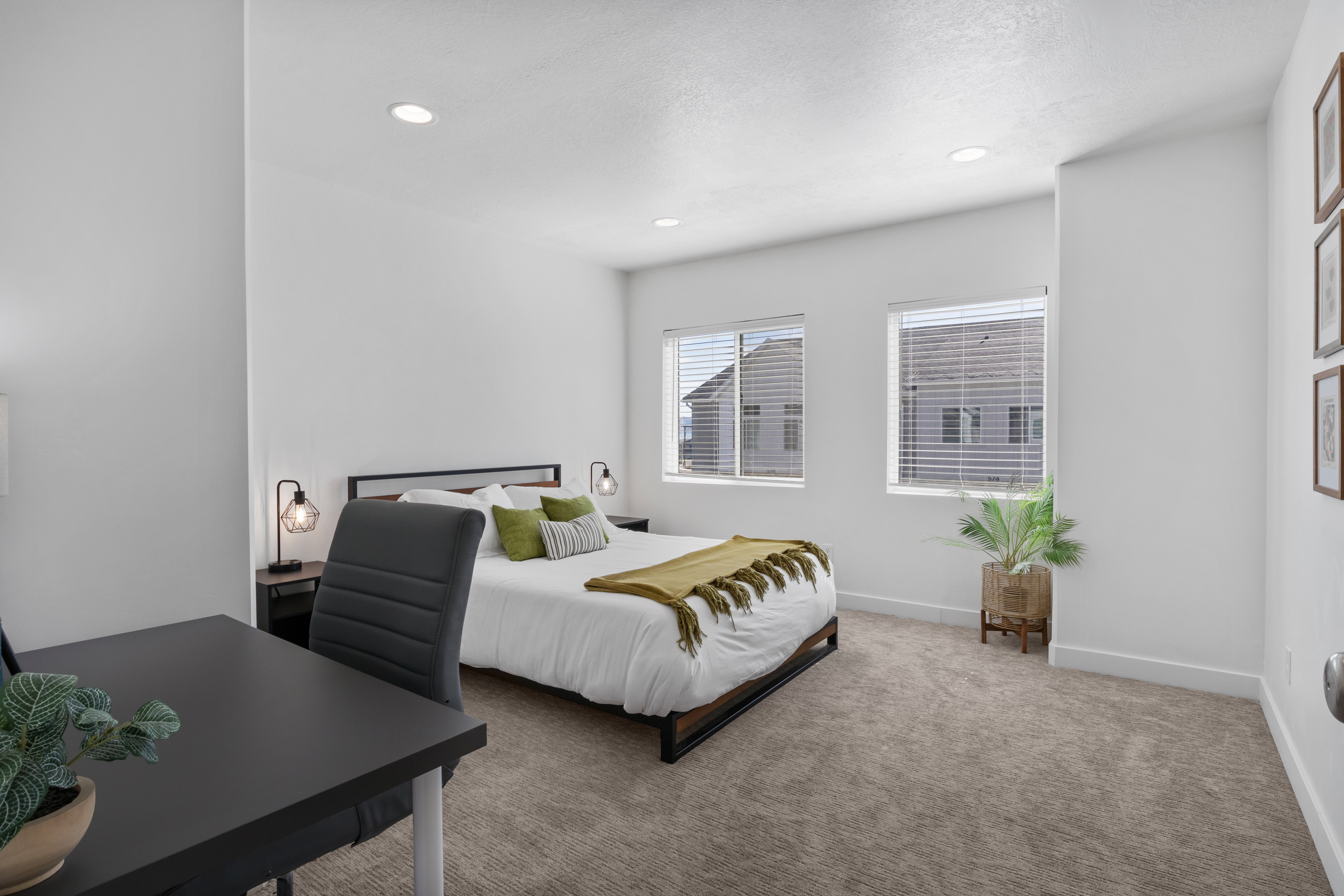 Spacious bedroom featuring neutral carpeting, two windows with blinds, recessed lighting, and ample wall space