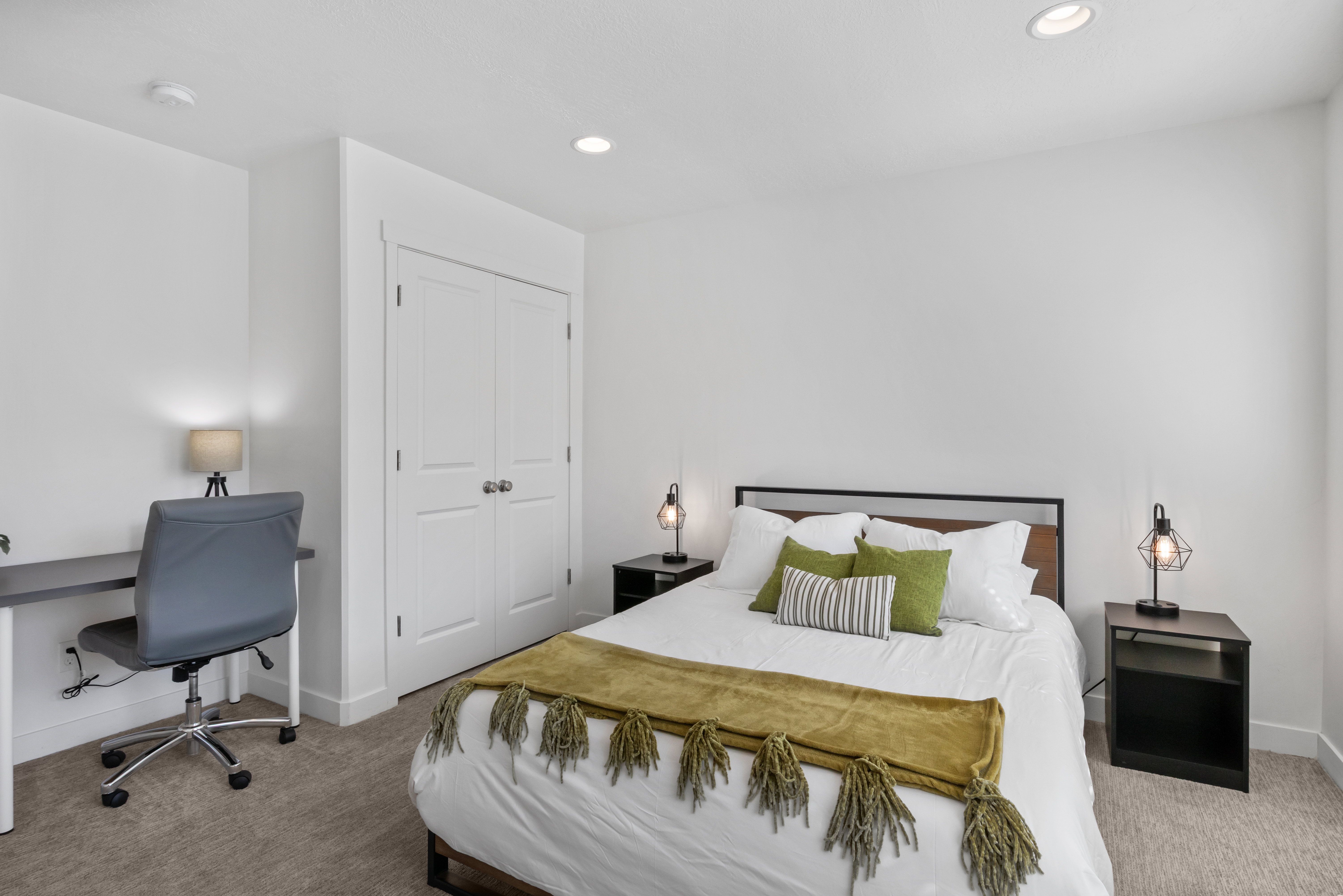 Carpeted interior space featuring white walls and recessed lighting