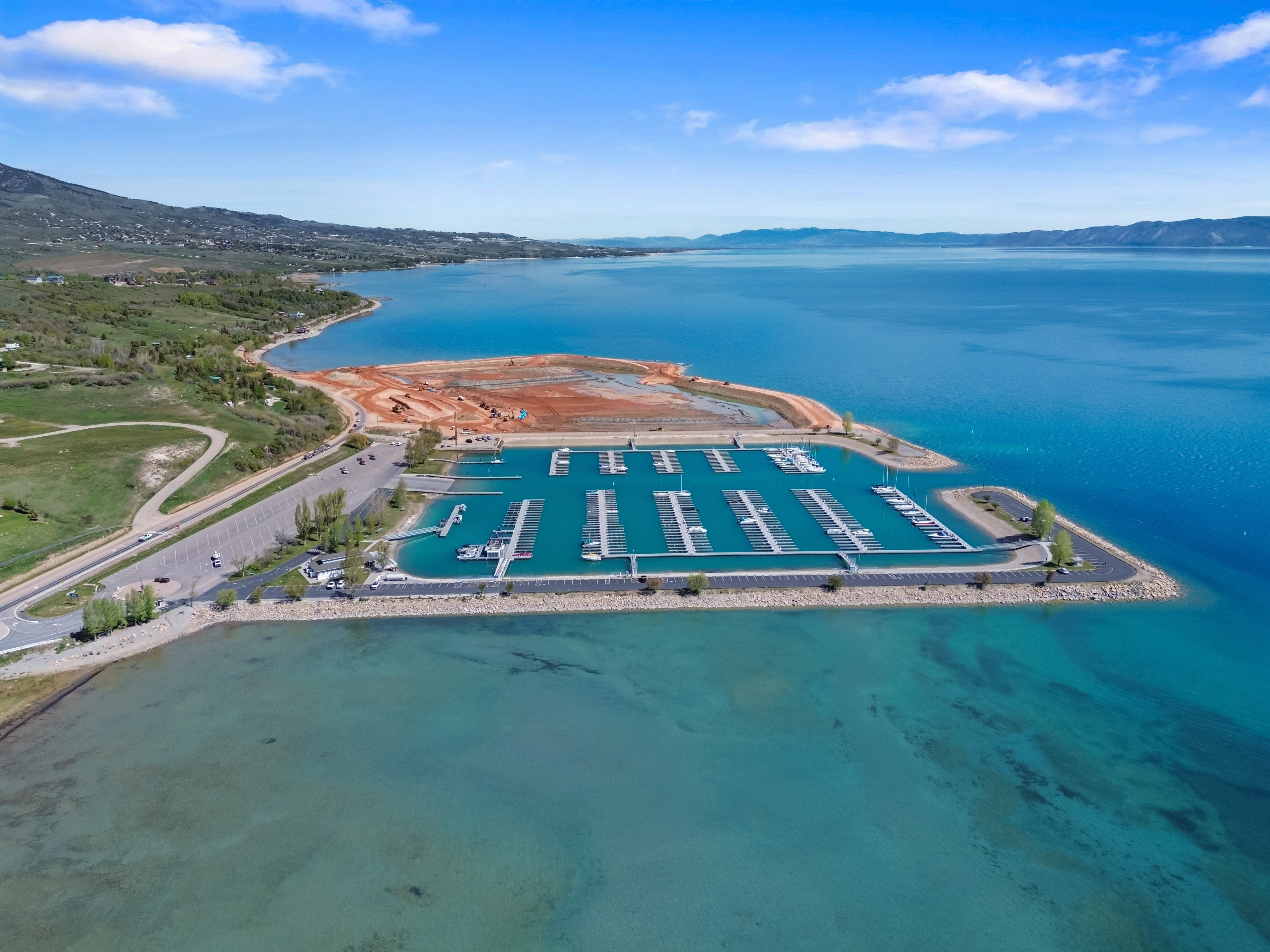 Expansive marina featuring multiple boat slips, paved parking areas, and robust breakwaters