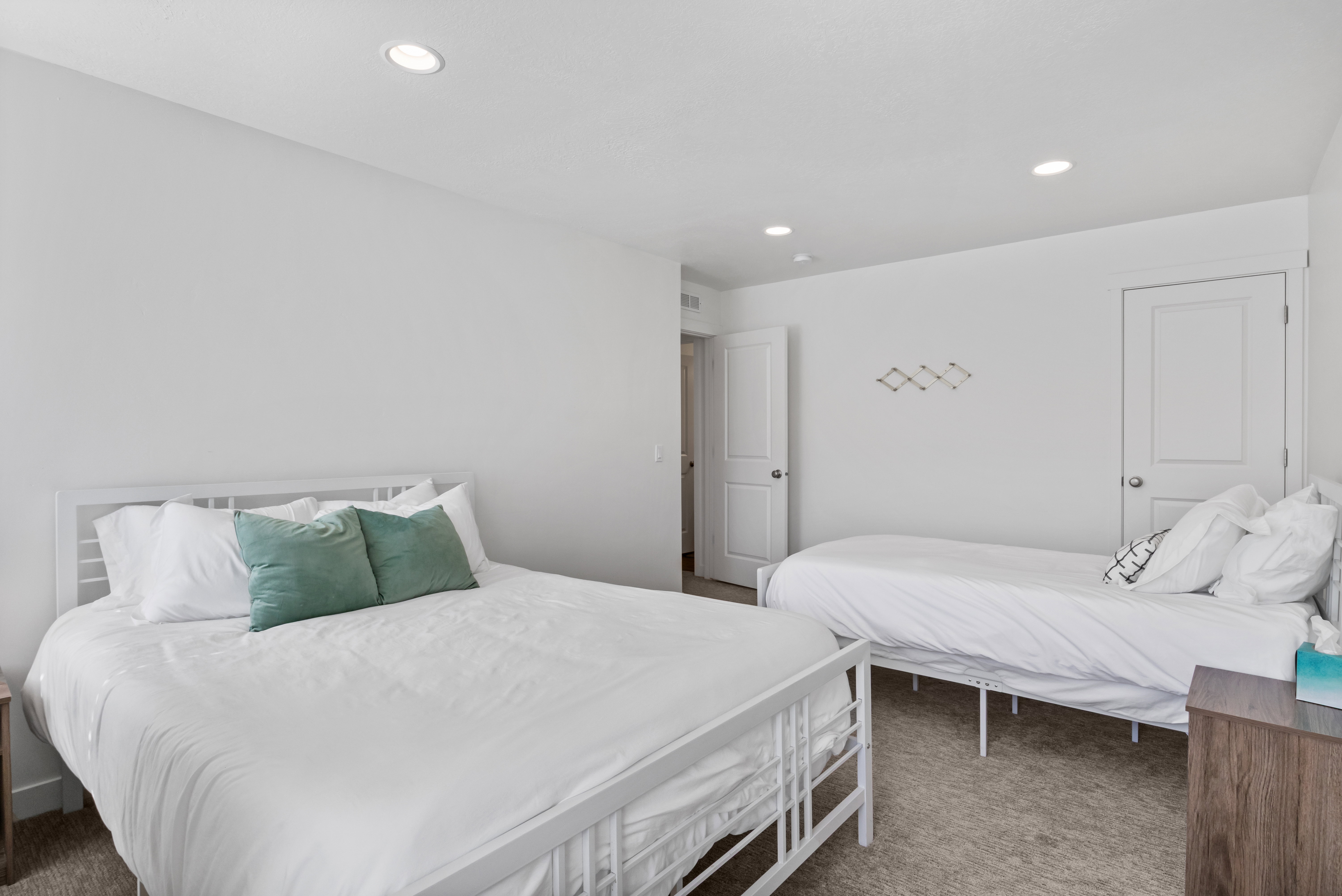 White walls and recessed lighting complement the neutral carpet flooring