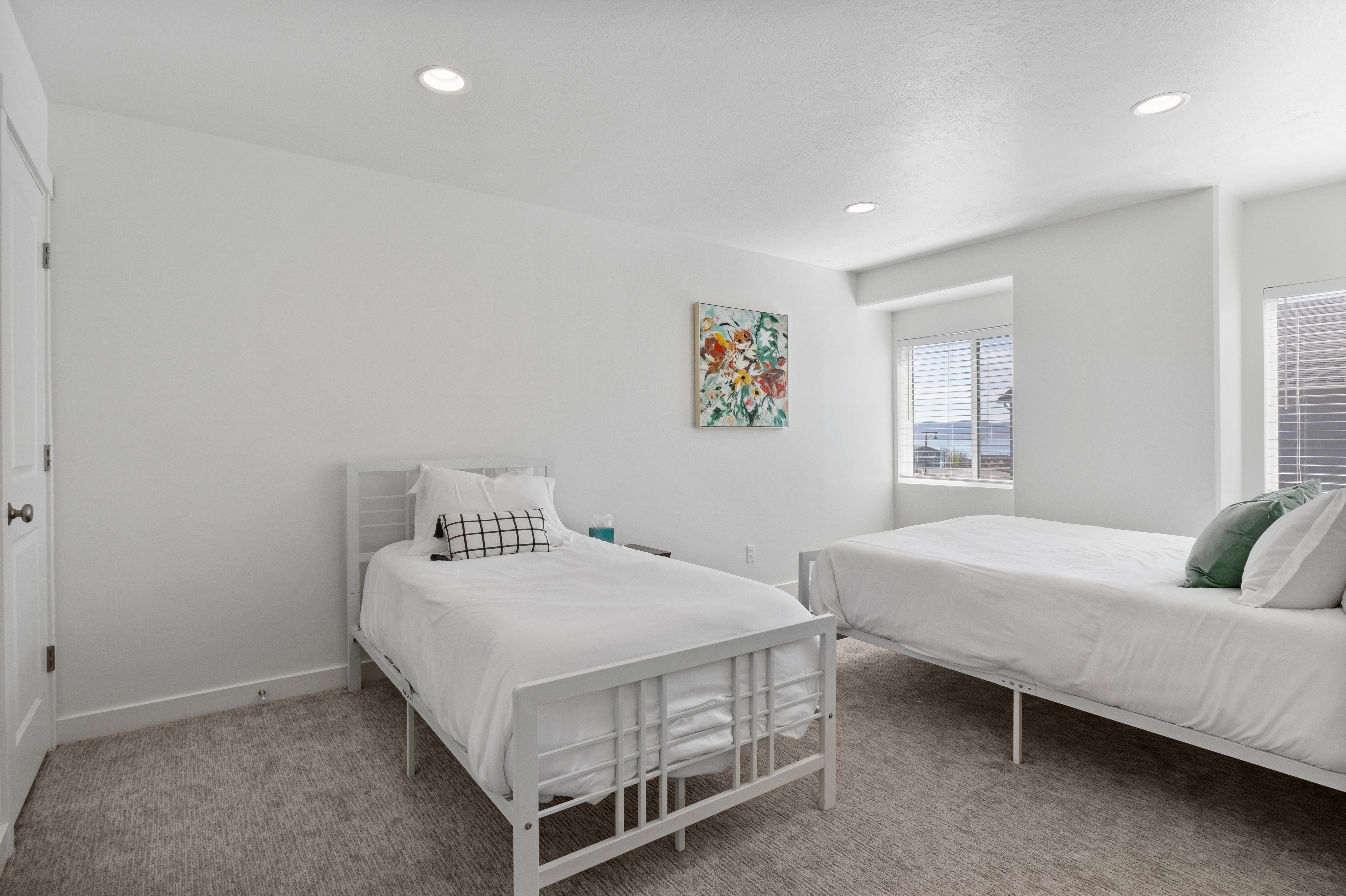 Spacious room featuring neutral carpeting, recessed lighting, white walls, and multiple windows