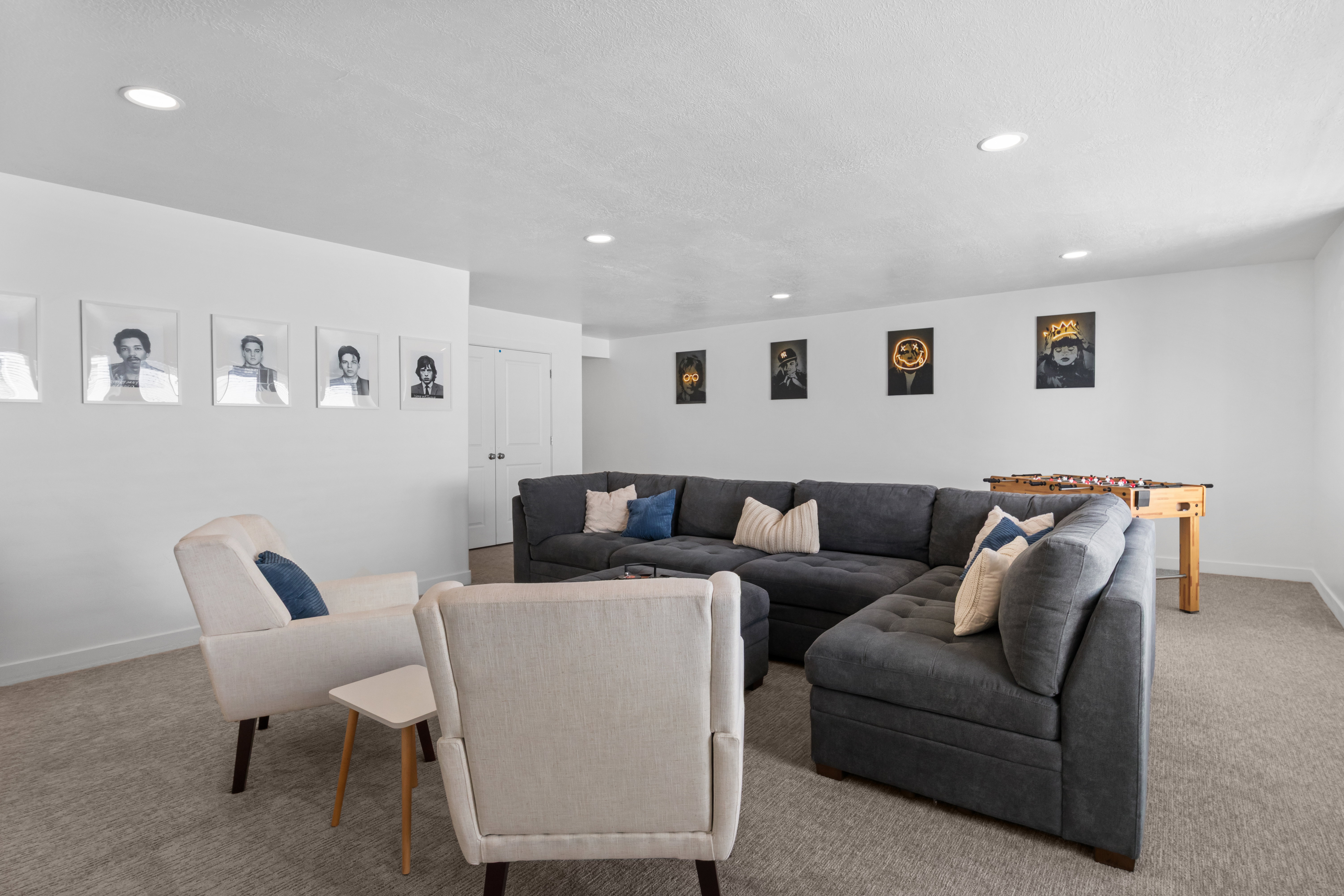 Spacious recreation room featuring recessed lighting, light-toned carpet flooring, white painted walls, and built-in closet doors