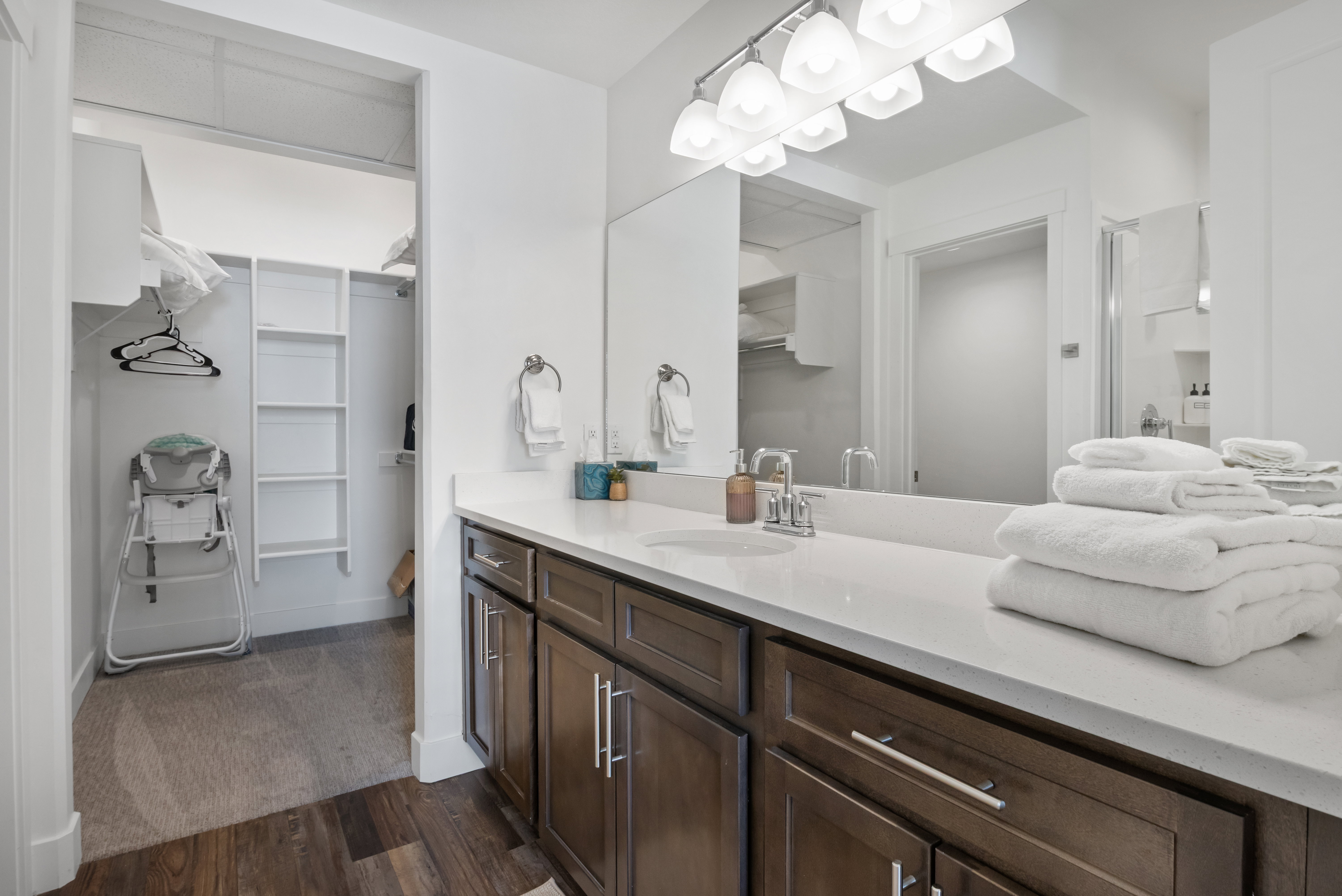 Vanity featuring a white countertop, undermount sink, and wood-finish cabinetry with brushed nickel hardware