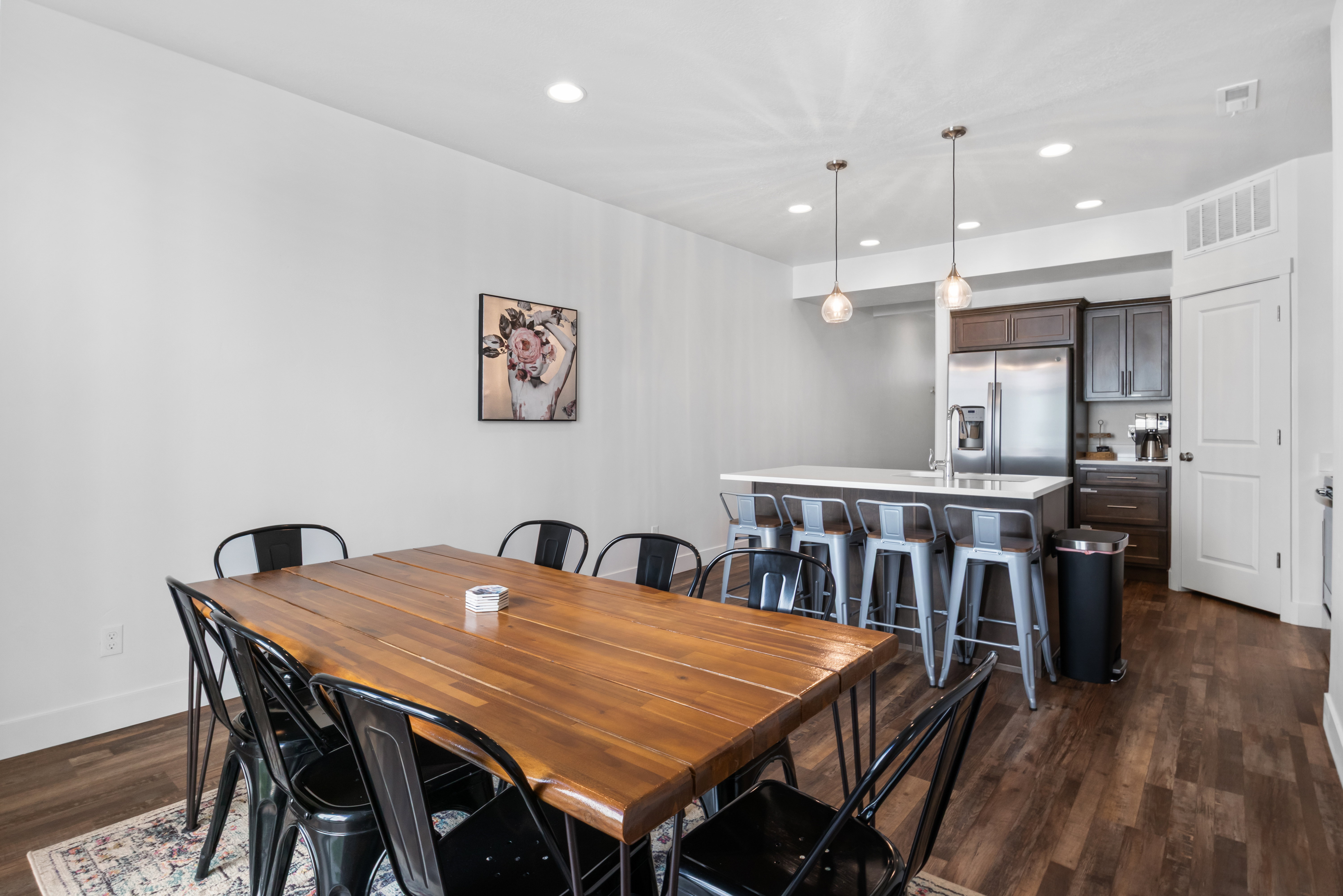 Open-concept dining area featuring wood-finish flooring, recessed lighting, and a white baseboard trim