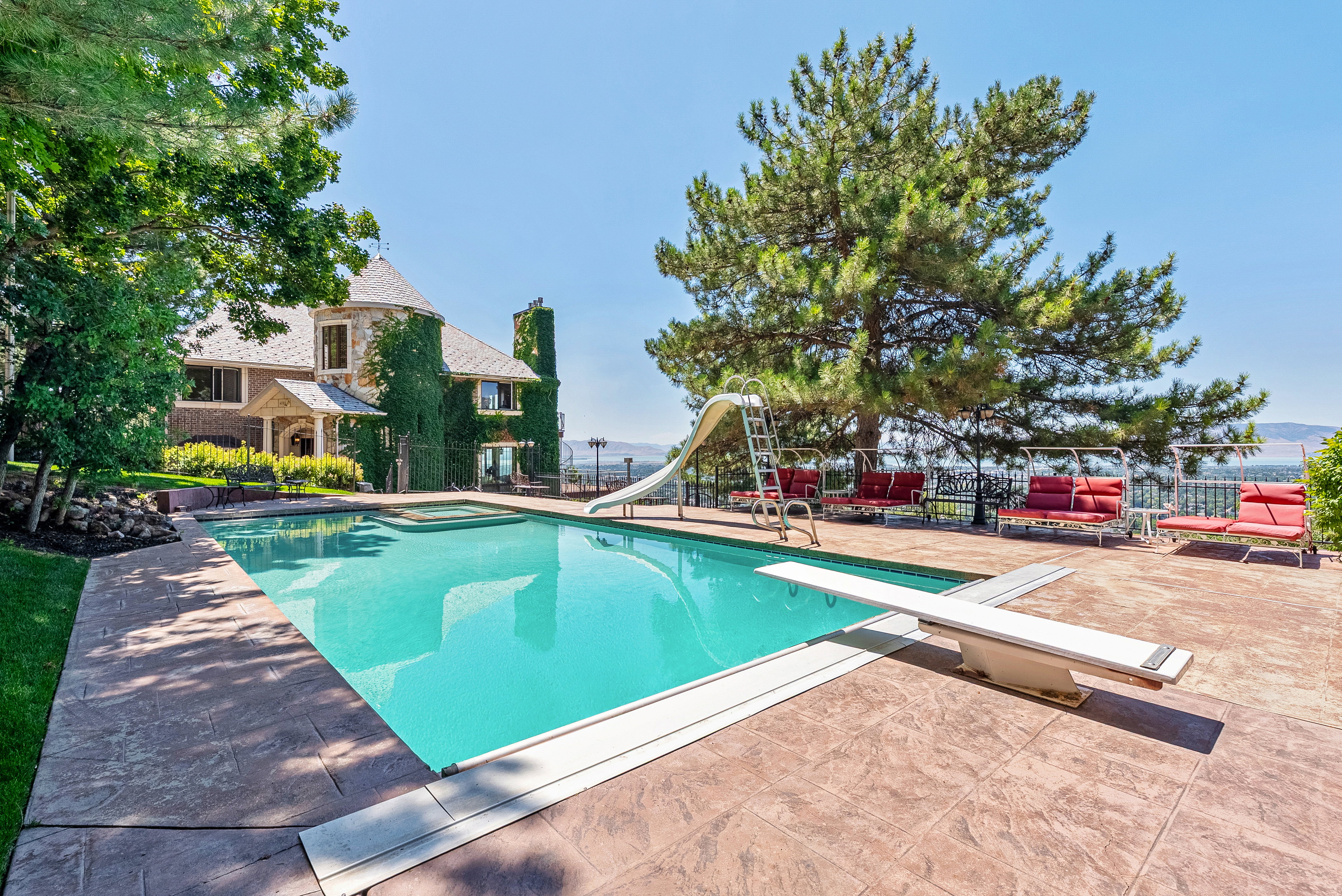 Rectangular swimming pool with an integrated spa, diving board, and slide