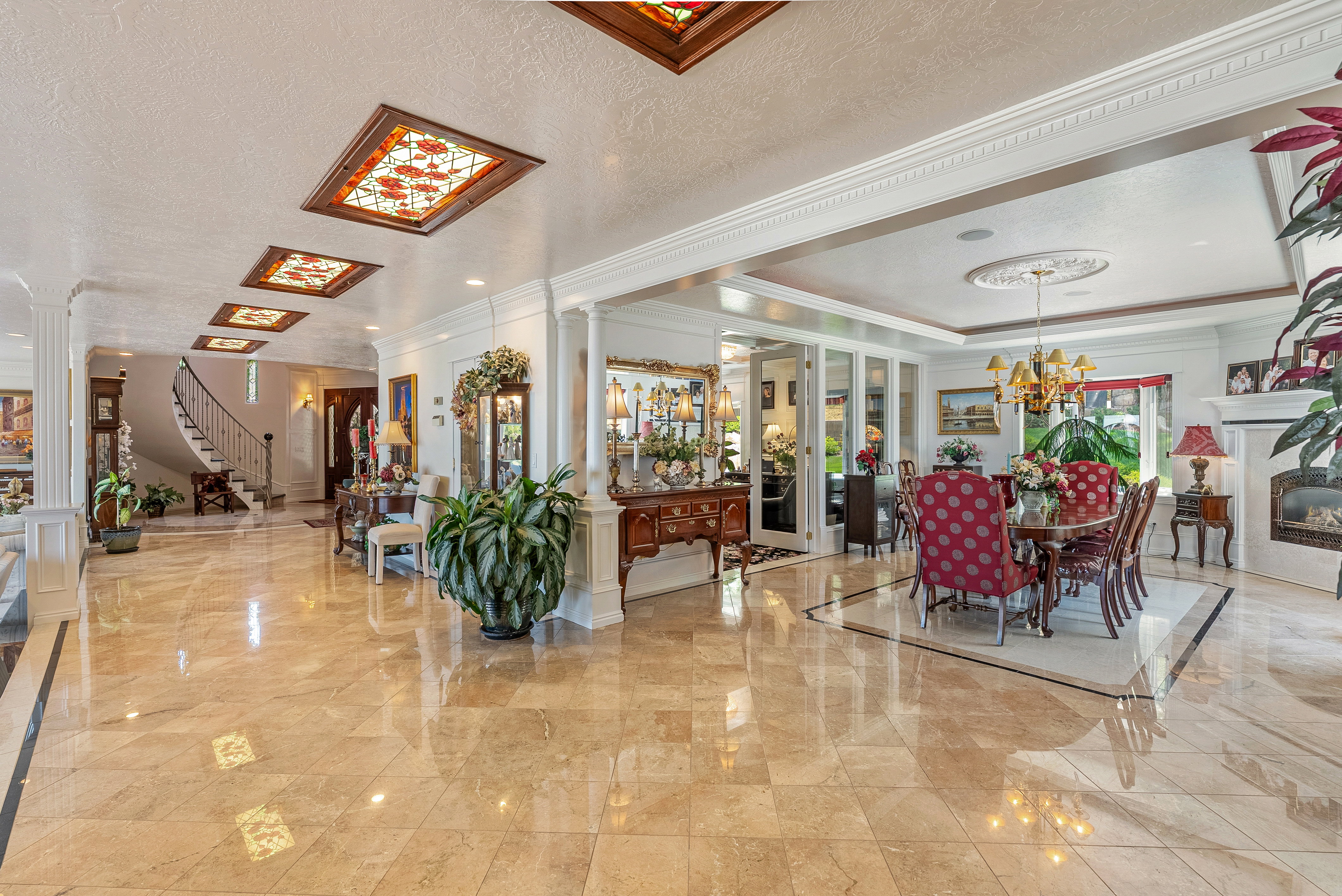 Grand entryway featuring polished stone flooring and decorative ceiling panels