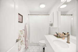 Bathroom featuring a white vanity with an integrated sink, brushed nickel faucet, and a large wall mirror