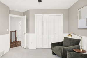 Room featuring light gray walls, white wainscoting, and a light-colored carpet