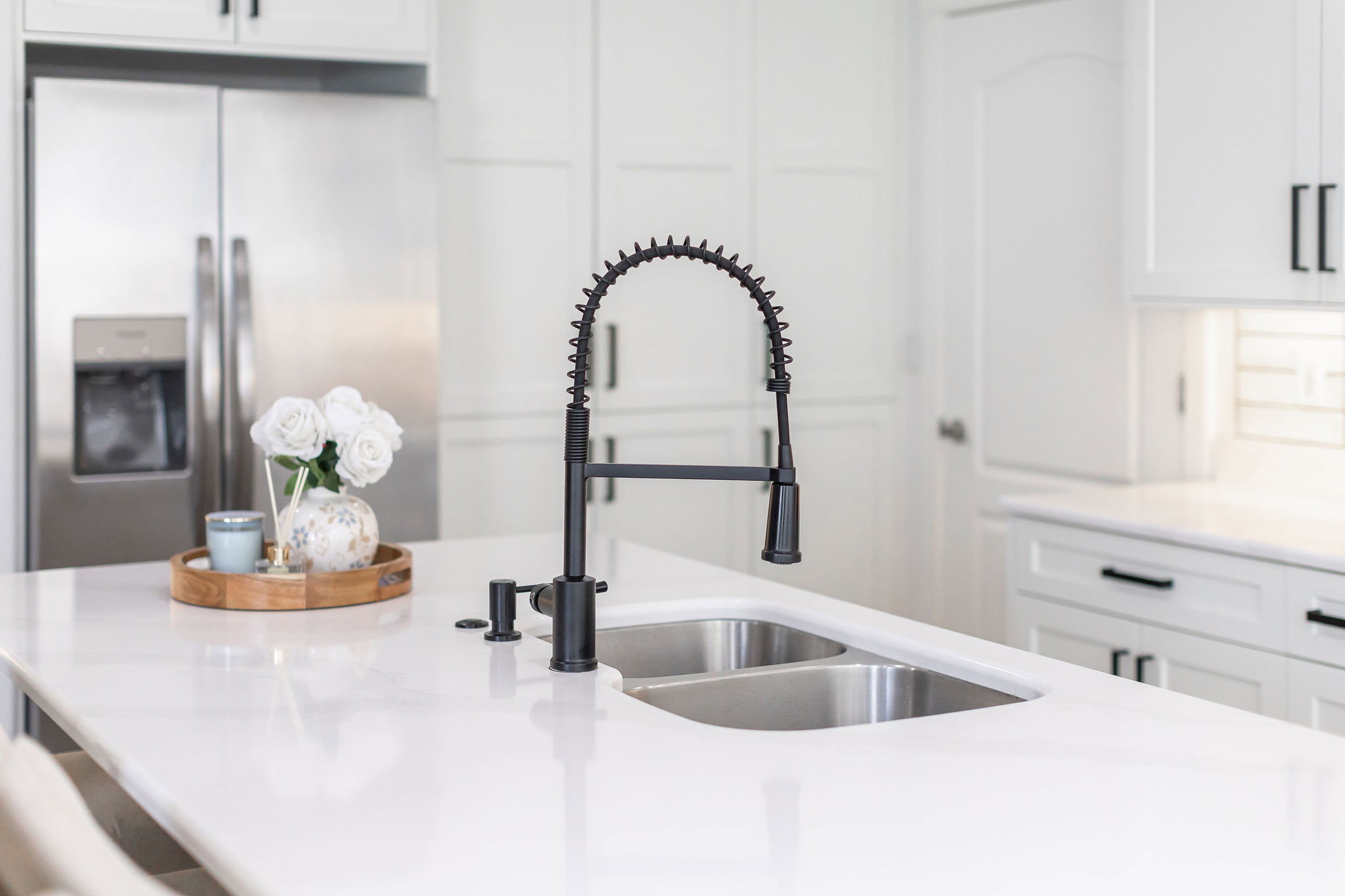 Kitchen island featuring a dual-basin stainless steel sink with a matte black coil spring faucet