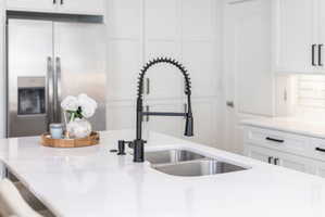 Kitchen island featuring a dual-basin stainless steel sink with a matte black coil spring faucet