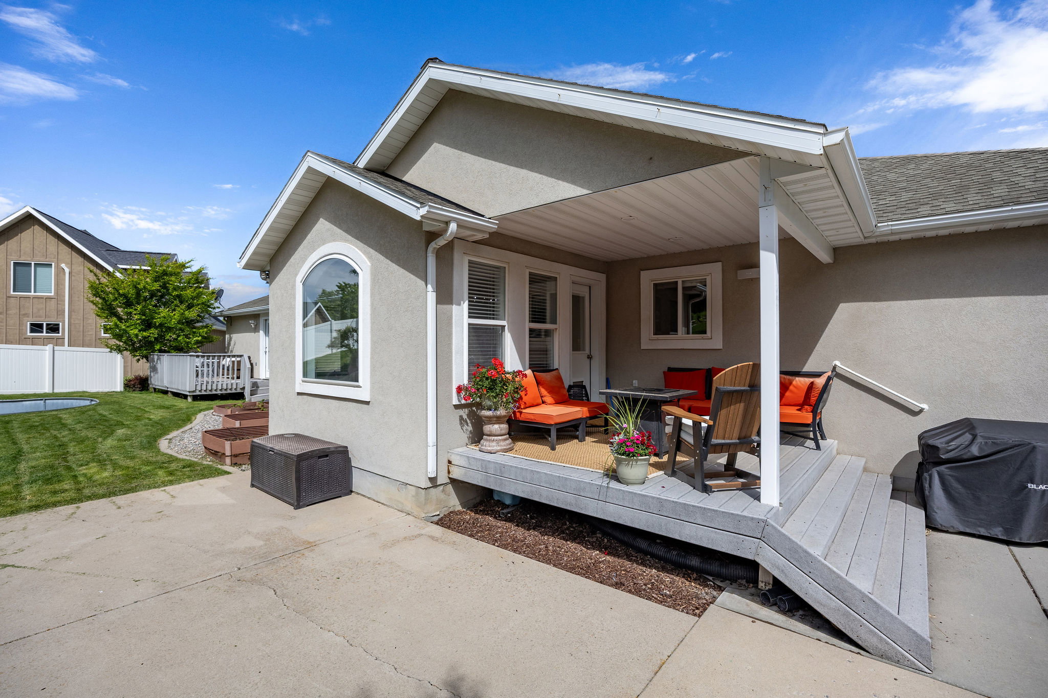 Covered deck area featuring composite decking and a stucco exterior