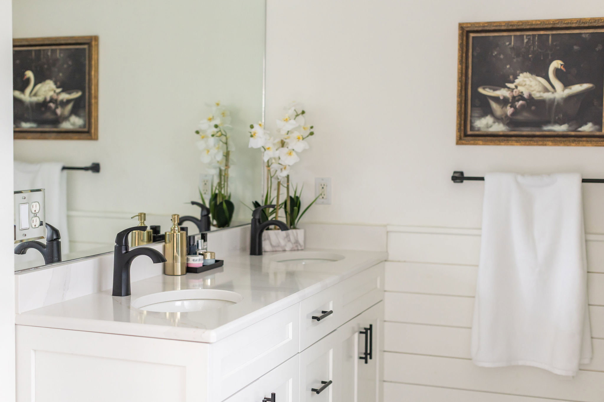 Dual vanity featuring undermount sinks, stone countertops, and matte black faucets