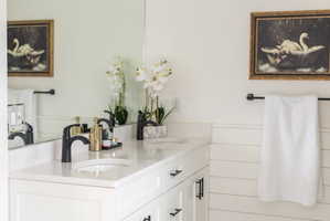 Dual vanity featuring undermount sinks, stone countertops, and matte black faucets