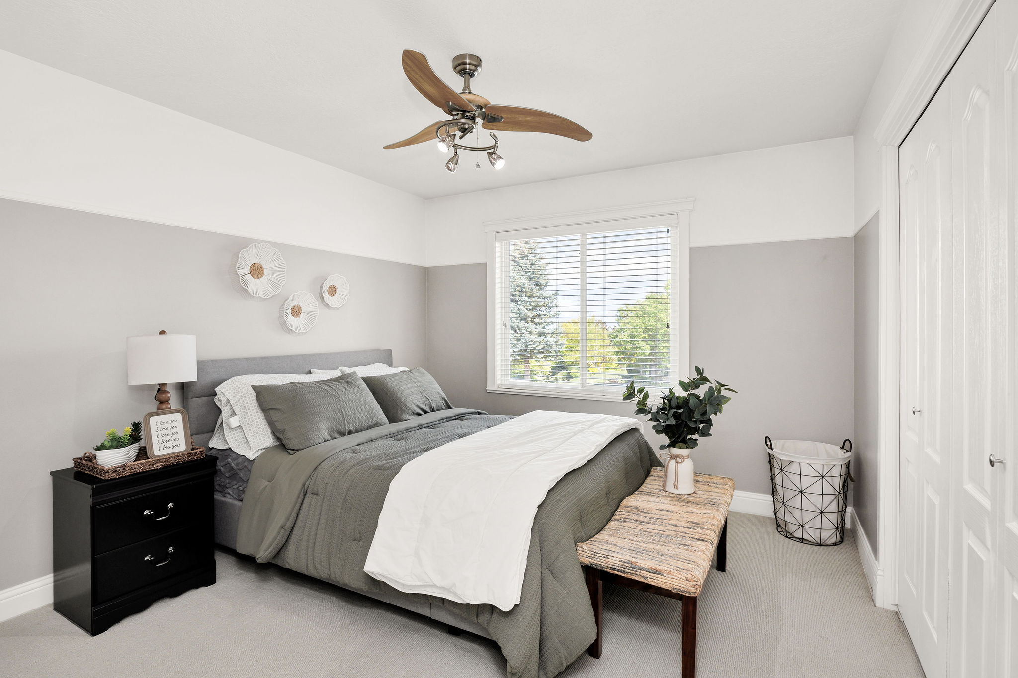 Carpeted room featuring a ceiling fan with integrated lighting, a window with horizontal blinds, and a paneled bifold closet door