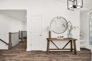 Spacious interior featuring wood-finish flooring, white walls, and a contemporary black metal framed light fixture