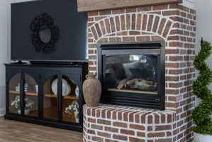 Exposed brick fireplace featuring an arched brick surround and dark metal insert