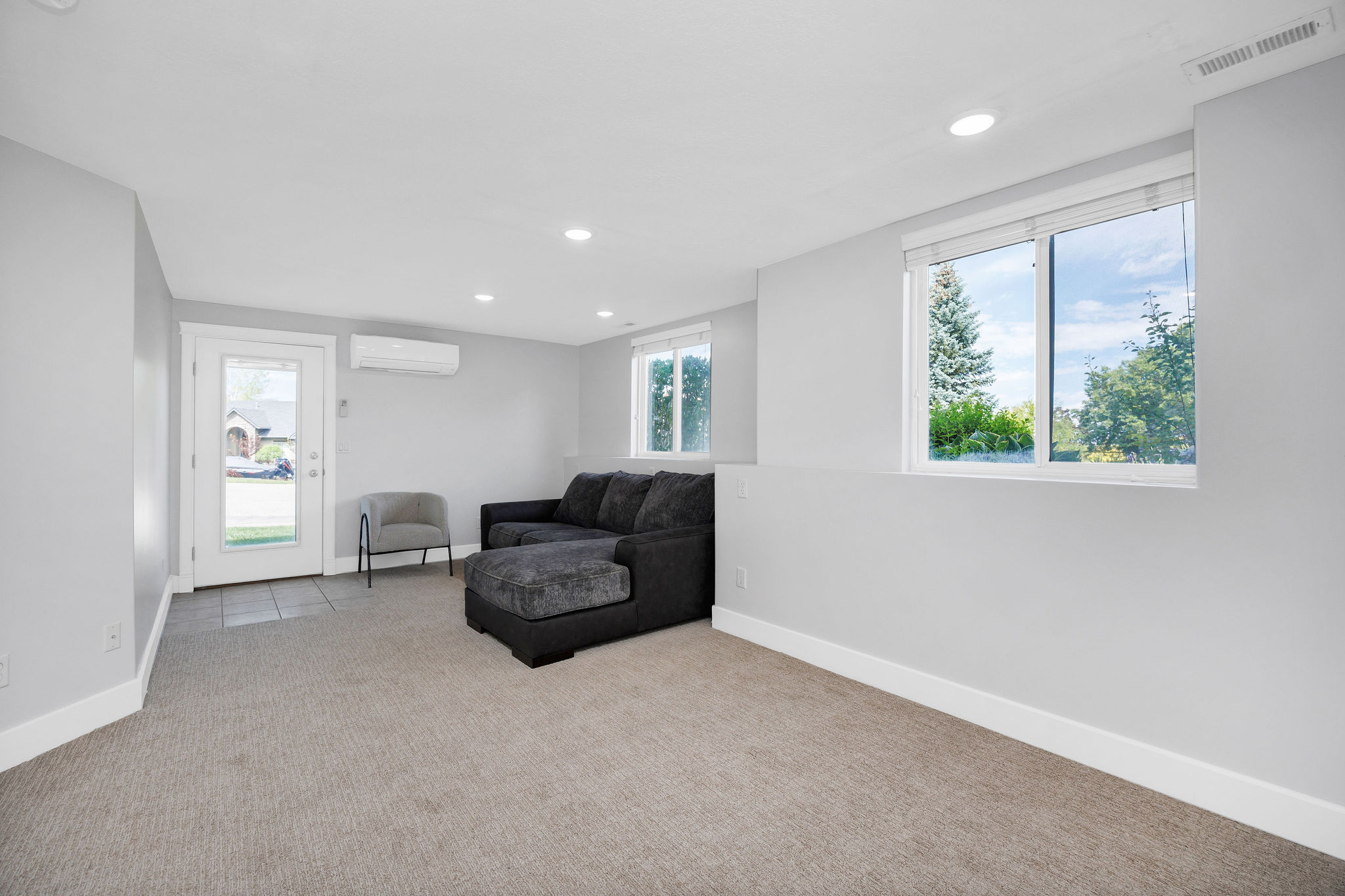 Spacious room featuring light gray walls, recessed lighting, and ample natural light from multiple windows