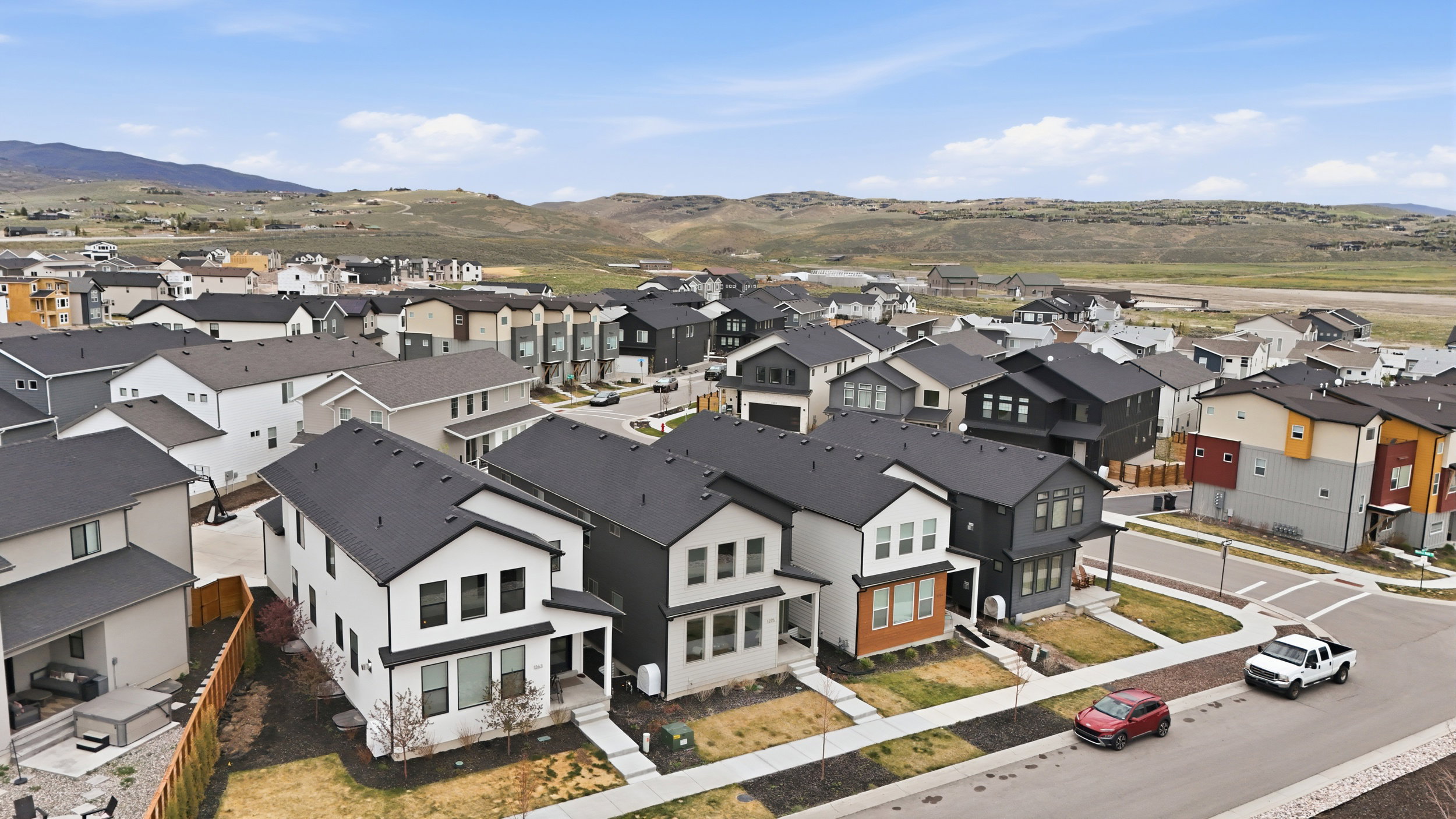 Modern residential development featuring varied architectural styles and dark-shingled rooftops