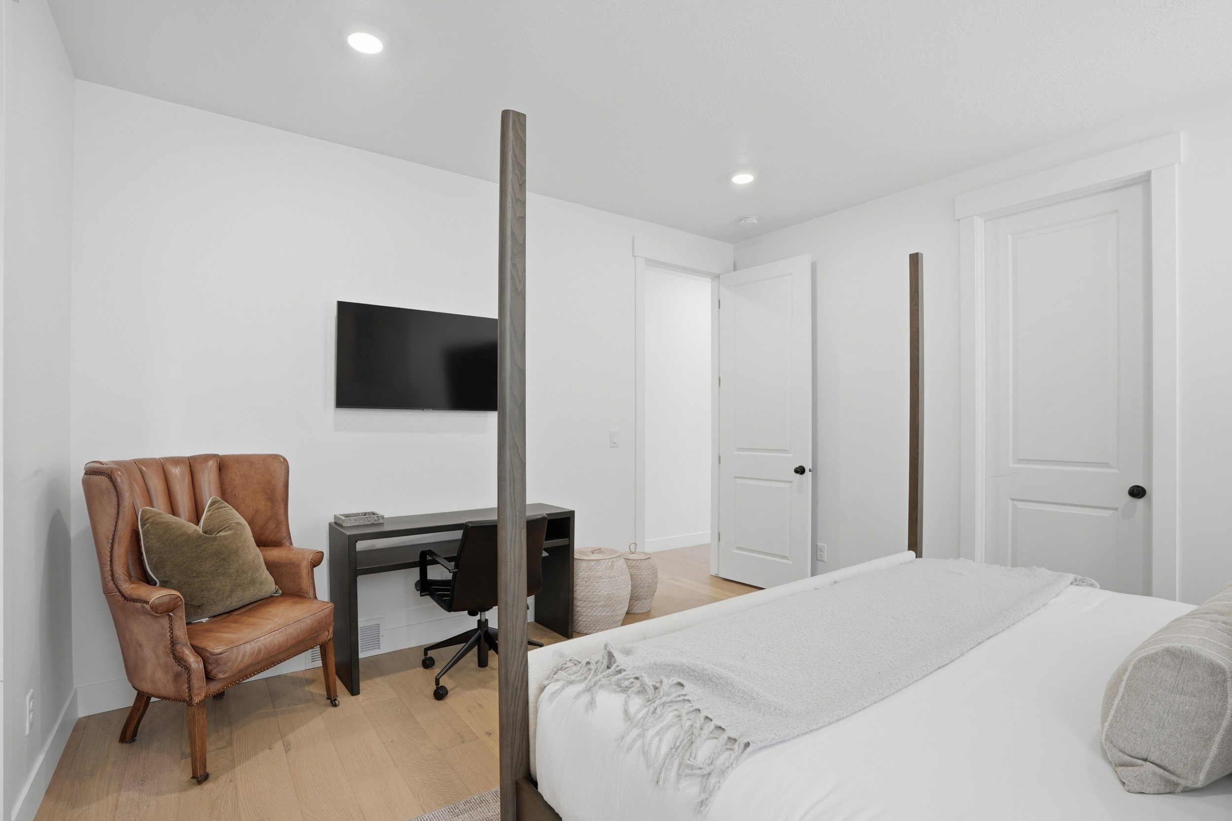 Light wood-finish flooring complements the crisp white walls and recessed ceiling lighting