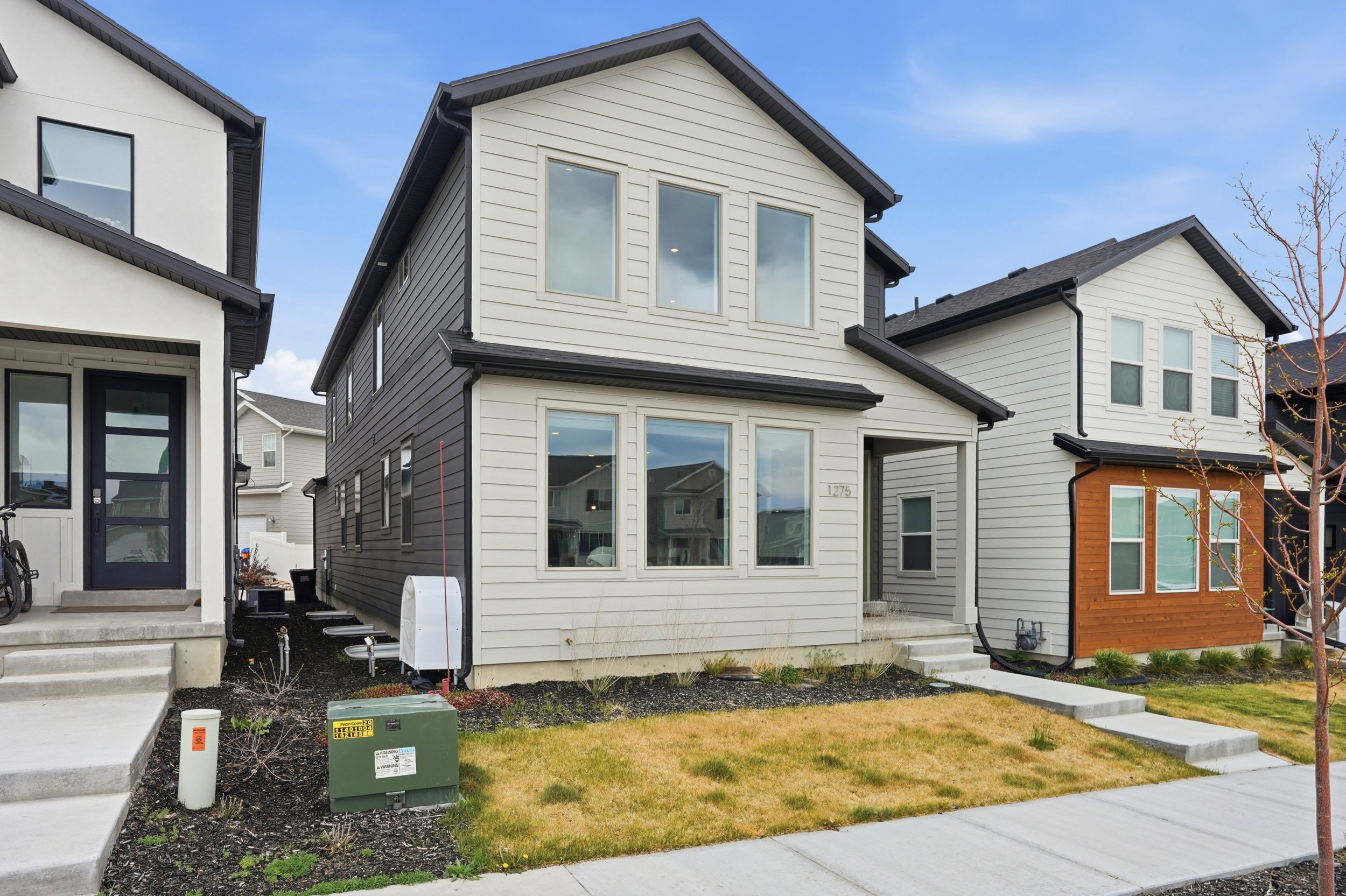 Two-story residence featuring light siding, dark trim, and a covered front entry