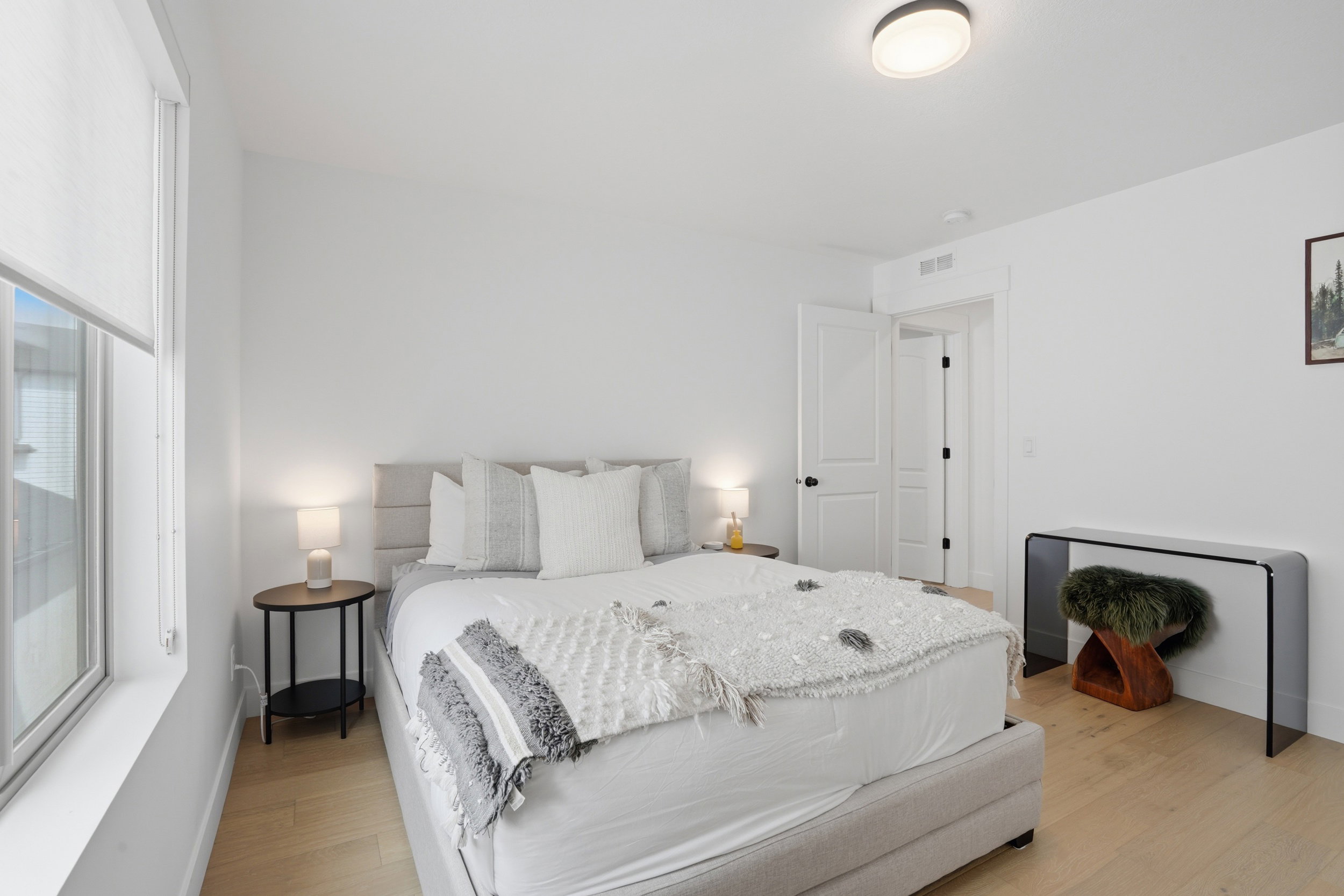 Bright interior featuring light wood-finish flooring, a contemporary flush mount ceiling light, and crisp white walls