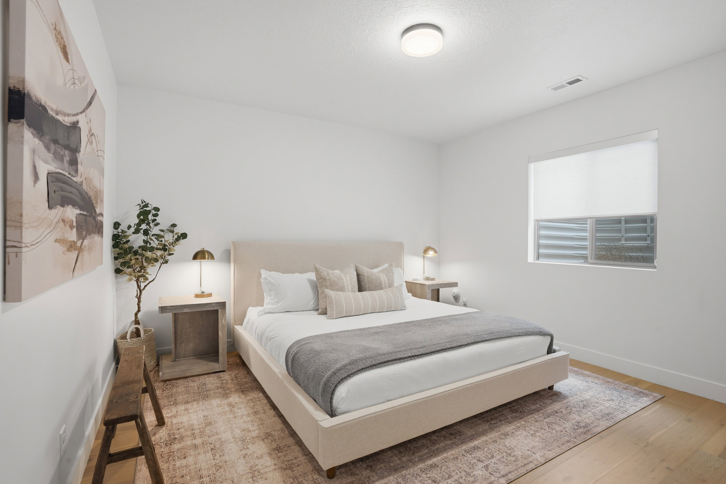Light wood-finish flooring with a neutral area rug