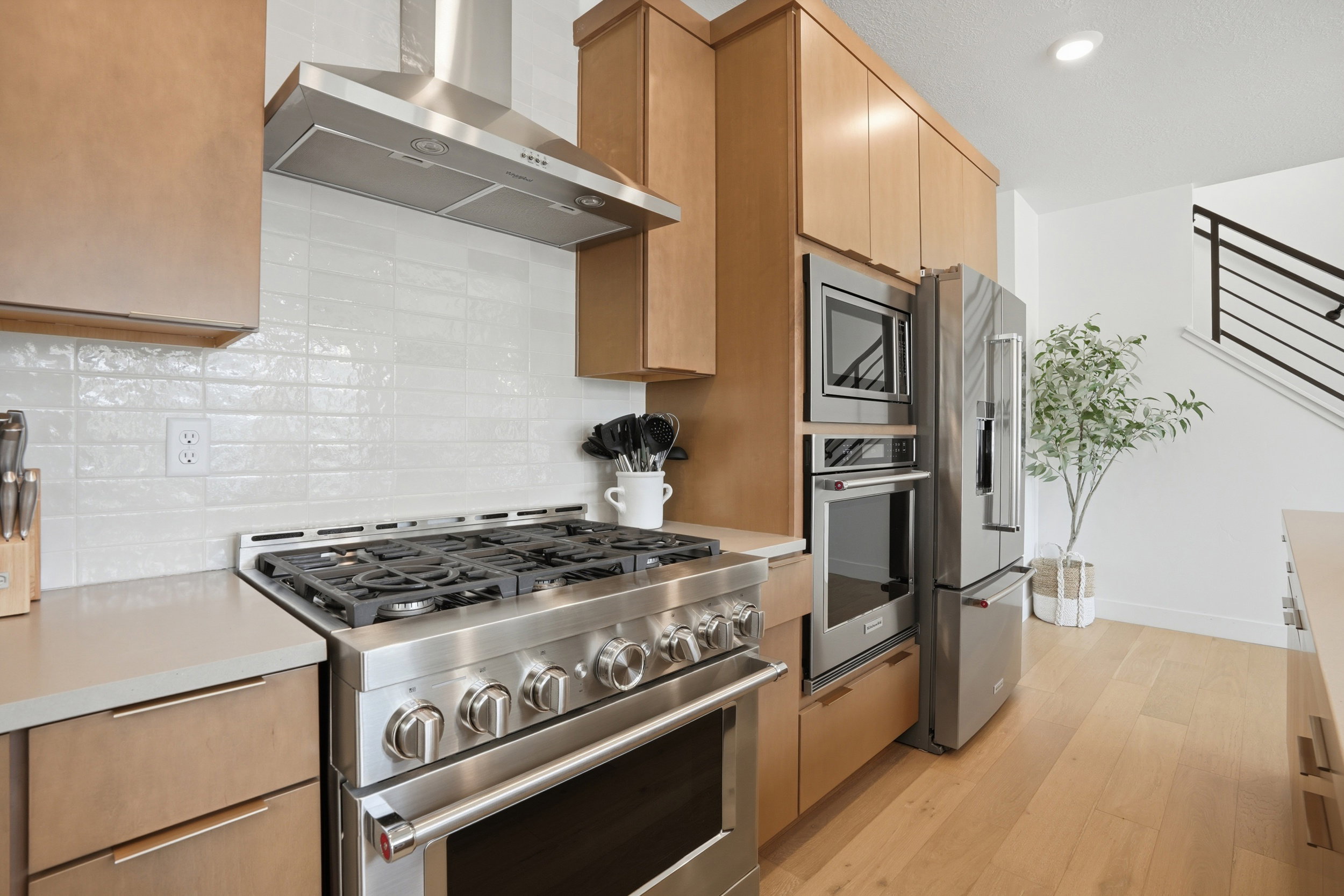 Gourmet kitchen featuring a stainless steel gas range with a matching hood, integrated wall oven and microwave, and a stainless steel refrigerator