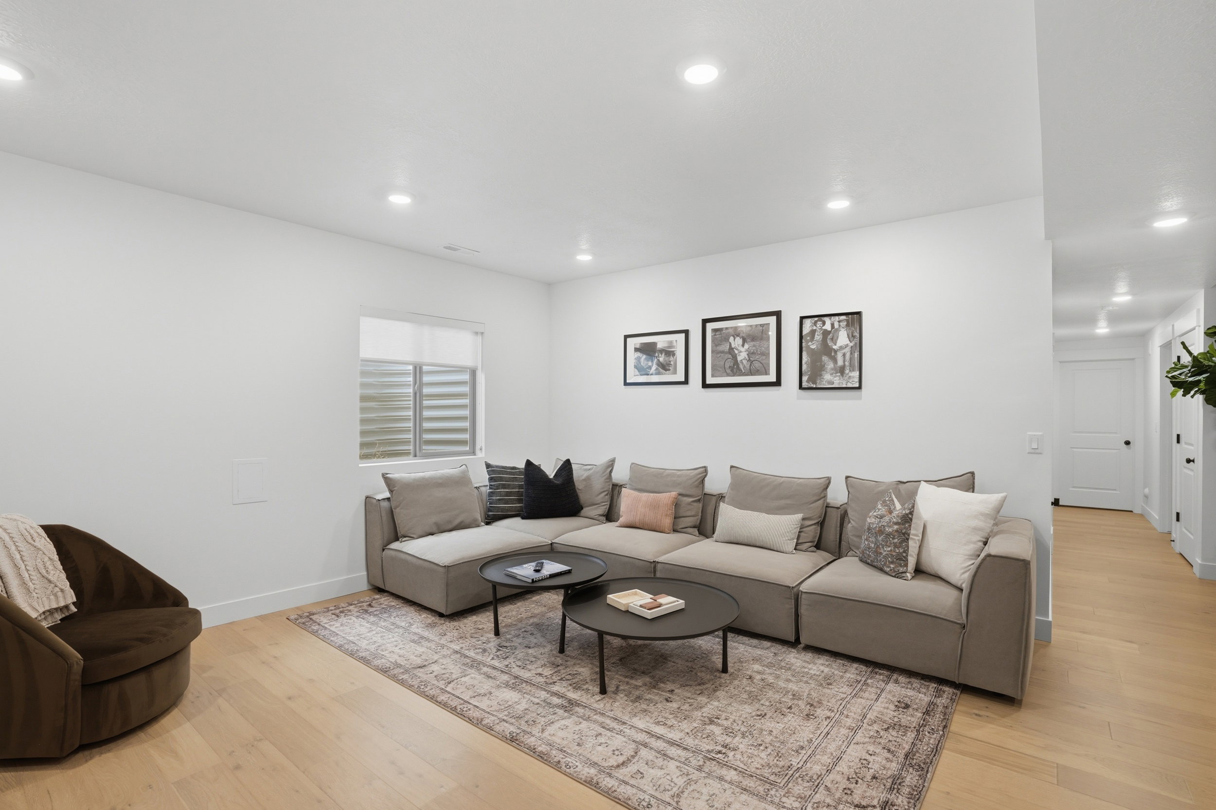 Recessed lighting illuminates this bright room featuring light wood-finish flooring