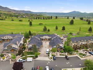 Townhome community featuring varied architectural styles, dark shingle roofs, and stone accents