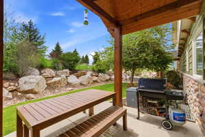 Covered patio with a concrete surface, wooden support beams, and tongue-and-groove ceiling