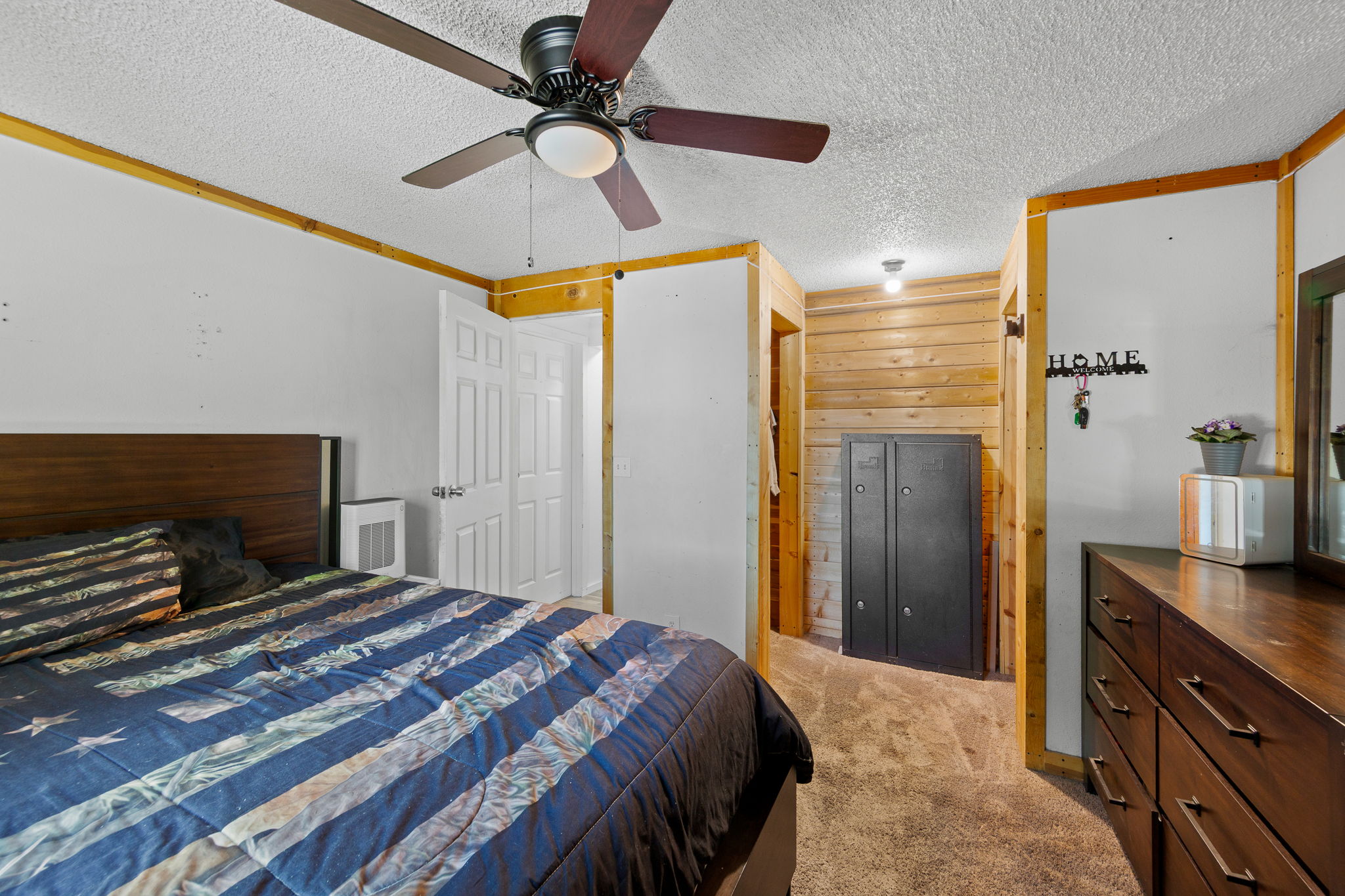 Bedroom featuring a wood-panel accent wall and wood-finish trim