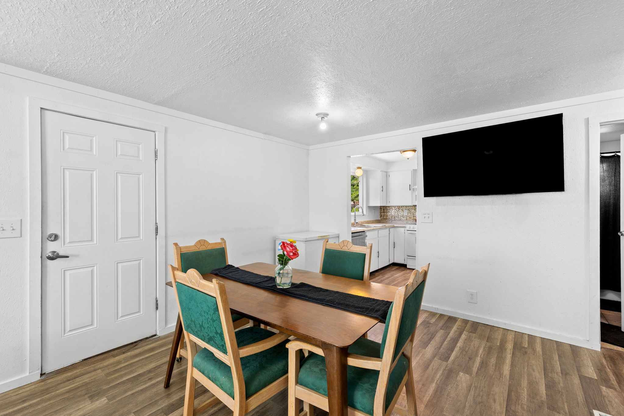 Dining area featuring wood-finish flooring and a white paneled door