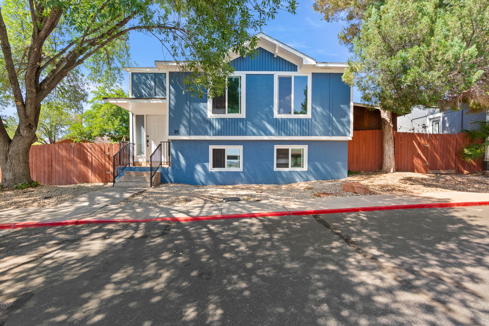 Contemporary facade featuring blue siding, white trim, and a covered entry