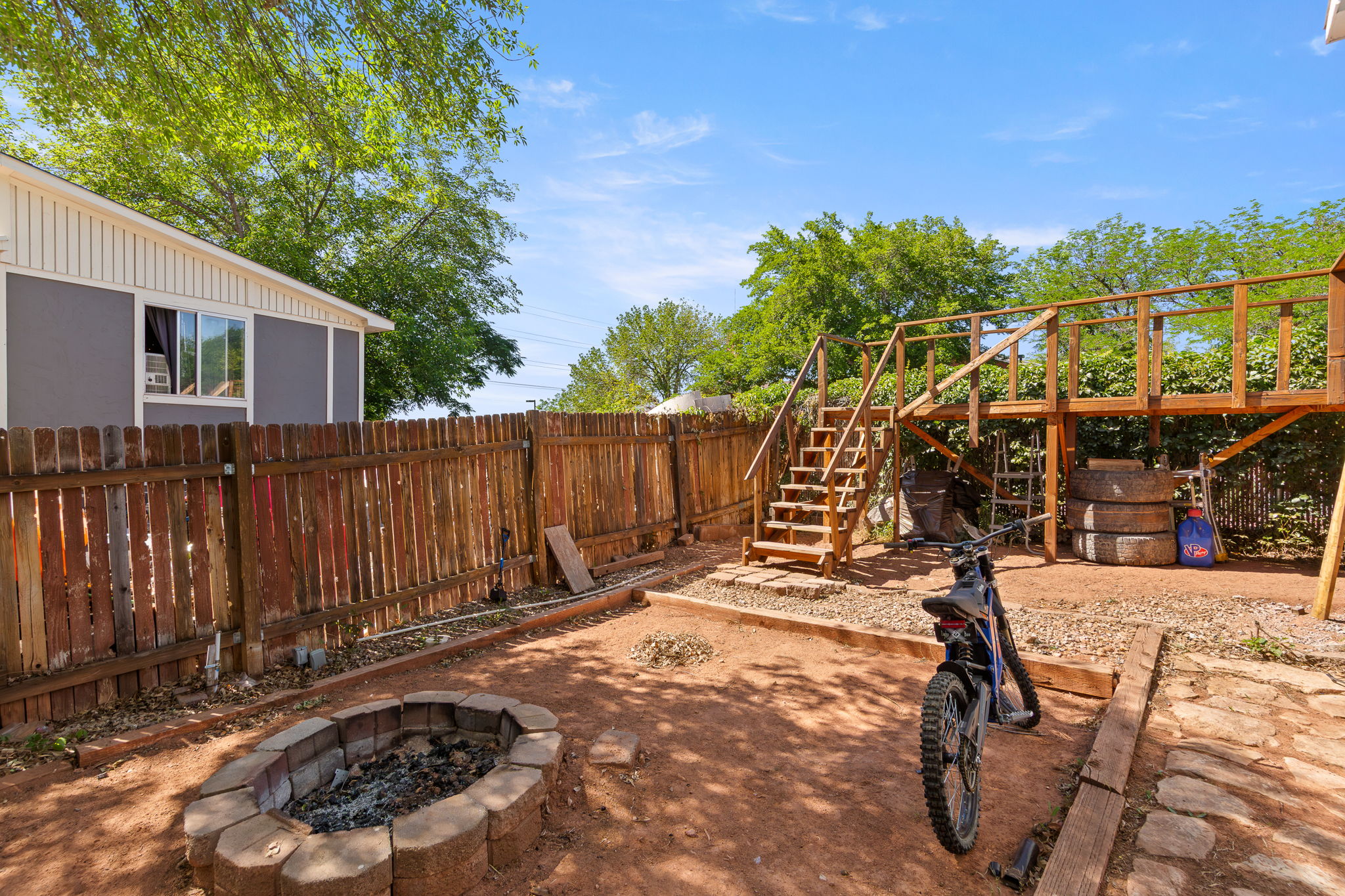Expansive backyard featuring a stone-lined fire pit