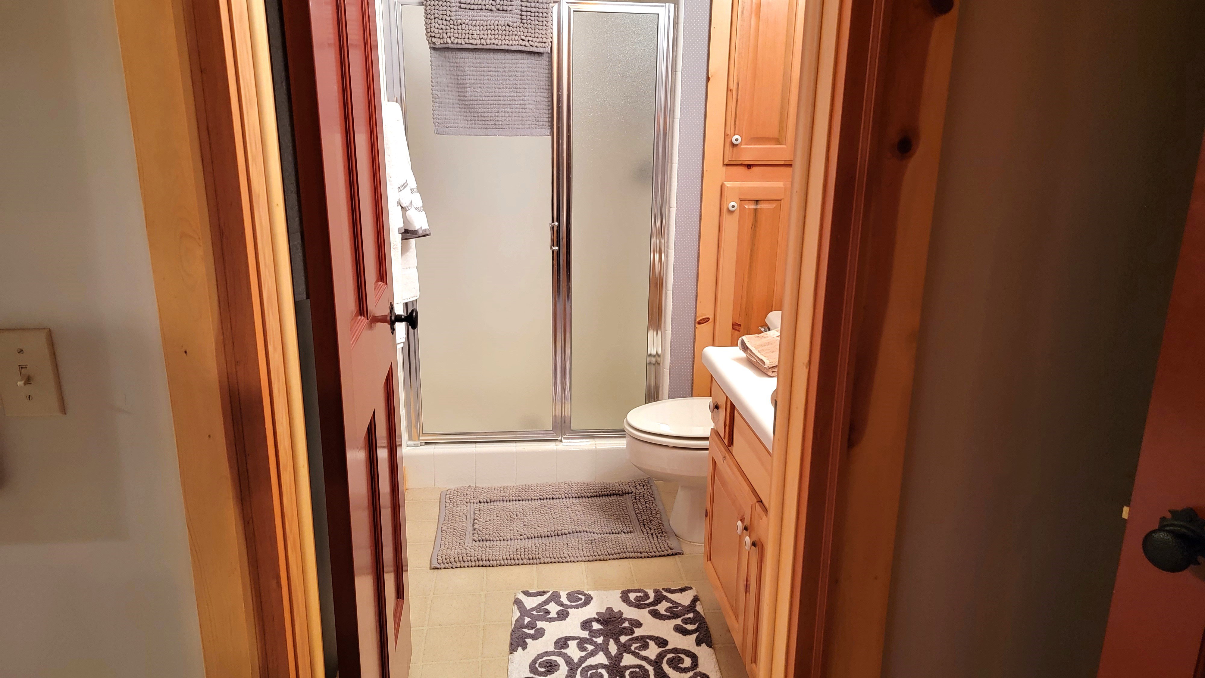 The bath has a large ceramic tile shower.