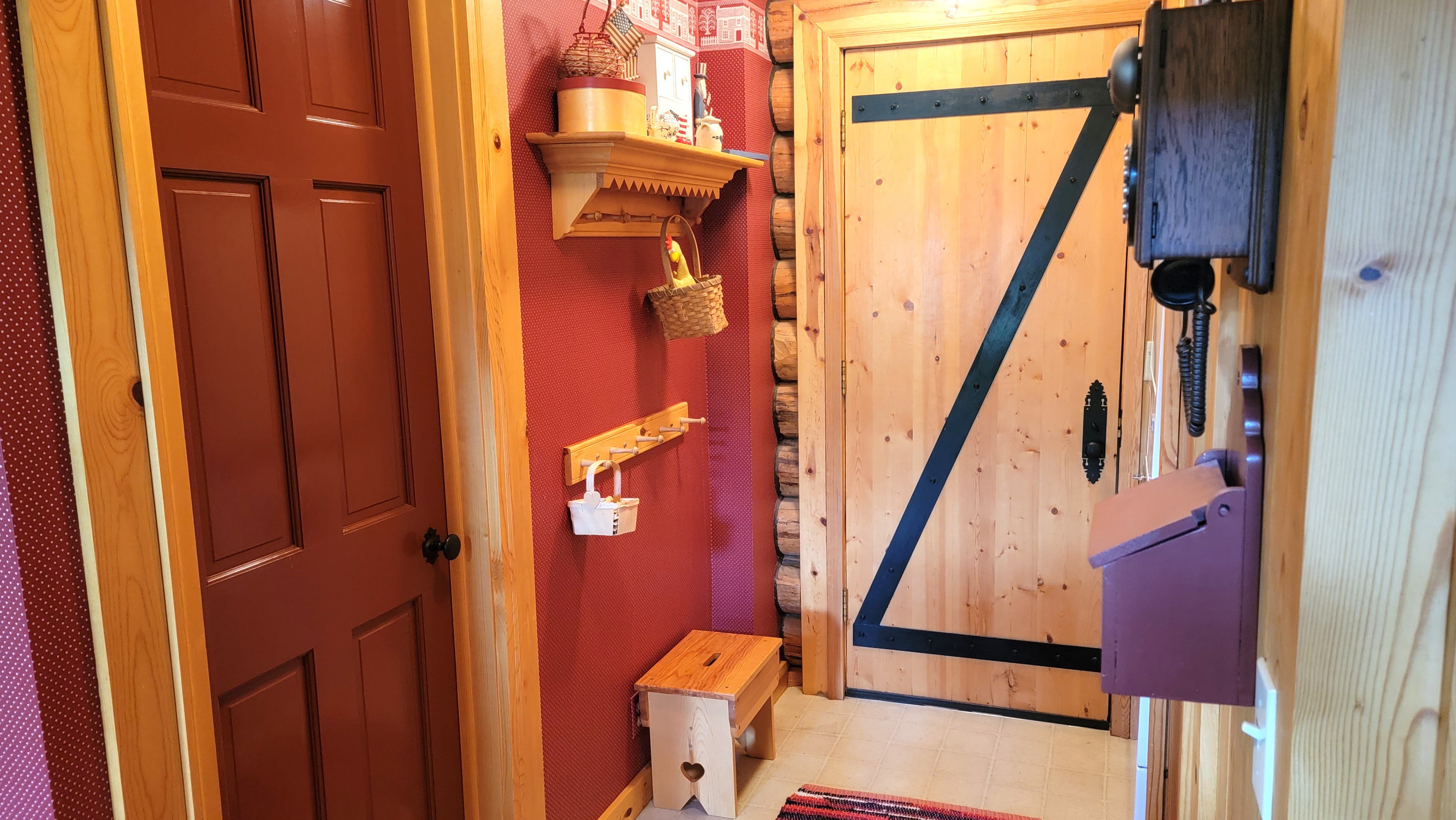 Coat racks, ornamental shelf & door to the full bath.