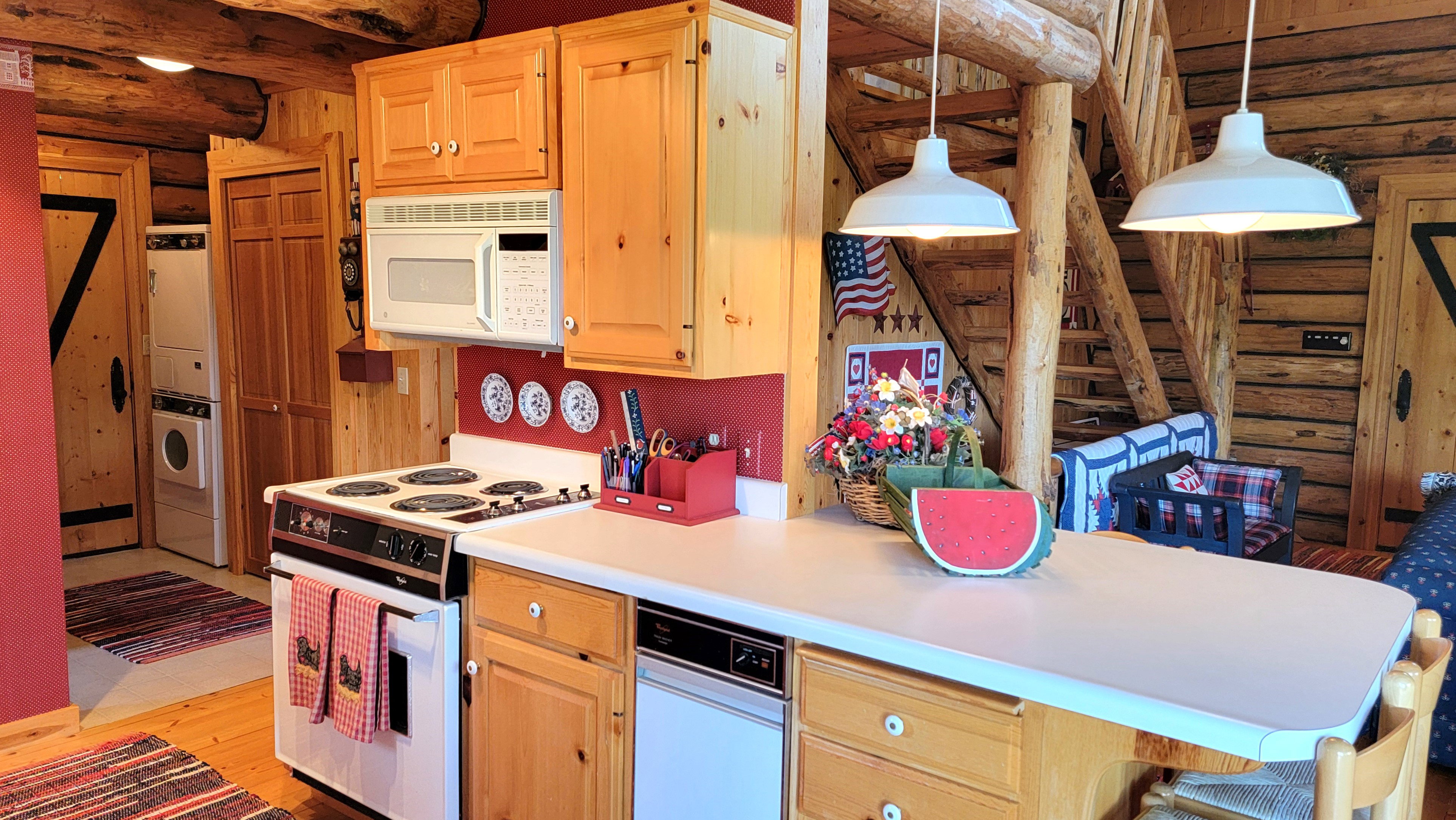 Kitchen view 4: The island, with trash compactor, microwave, range and pendant factory lighting.
