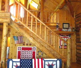 View of the log staircase to the loft, with log railings.