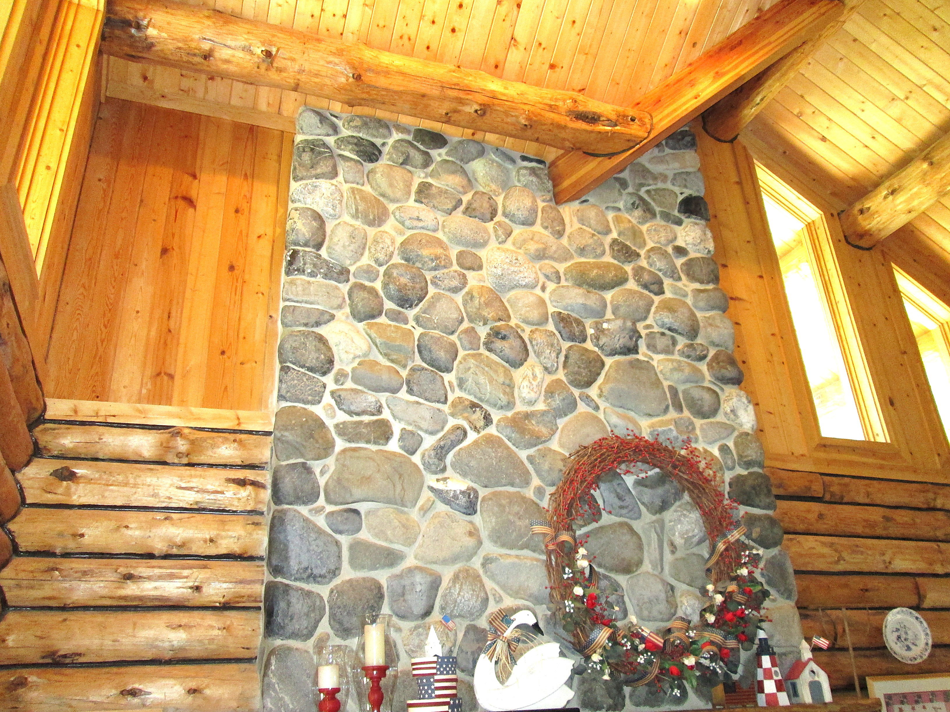 View of the upper great room showing the top of the river rock fireplace and the clerestory windows.