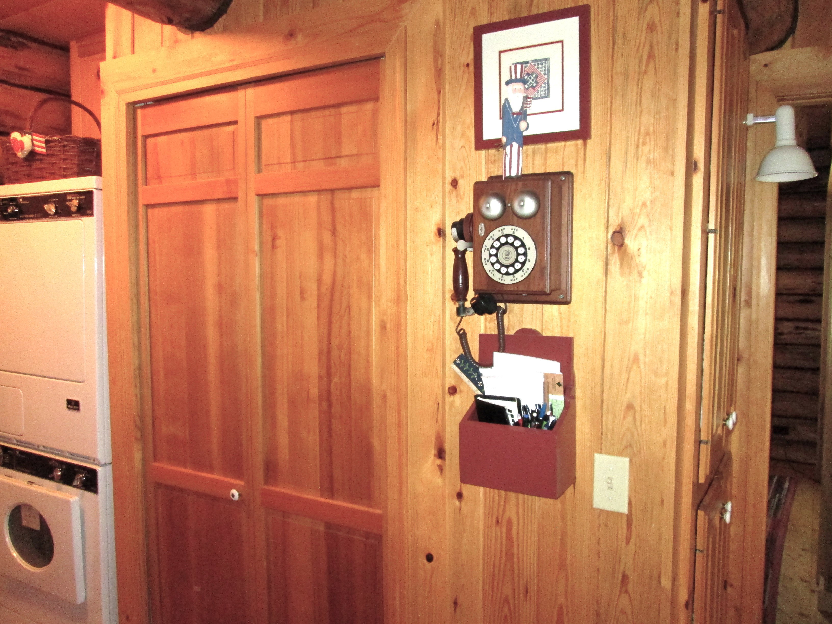 The laundry room has a deep utility closet and vintage working phone.