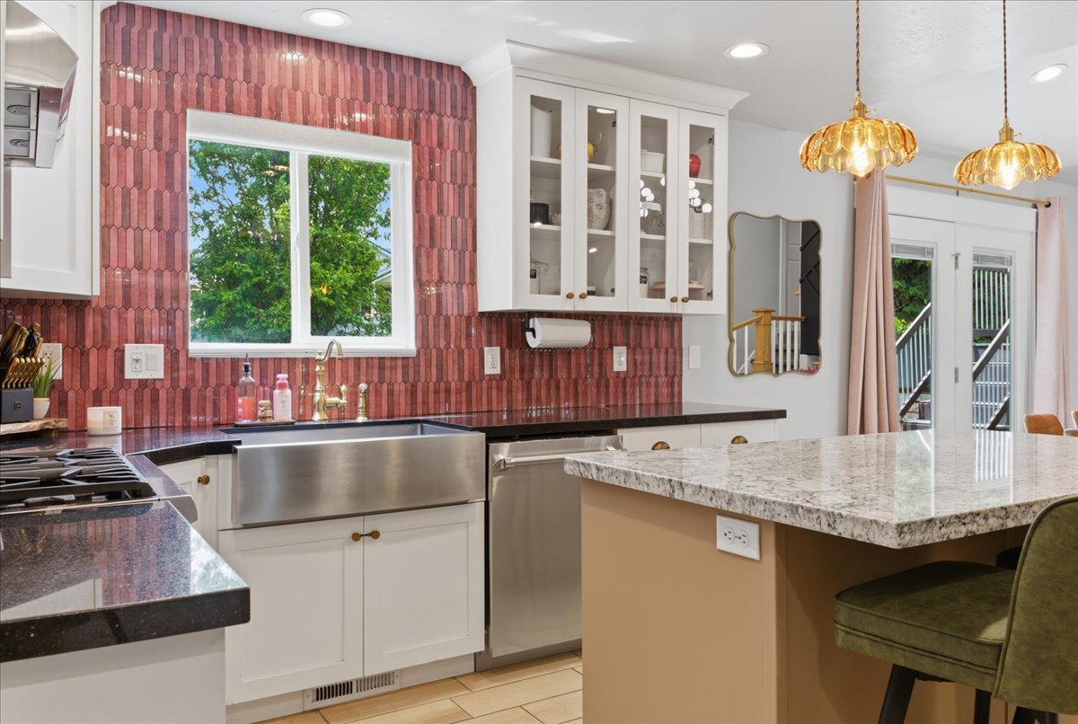 Spacious kitchen featuring a stainless steel appliances, granite countertops, and accented backsplash