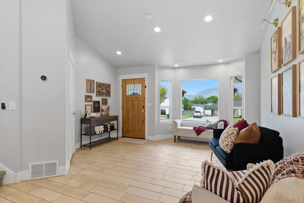 Light tile flooring extends through this room featuring a wooden entry door