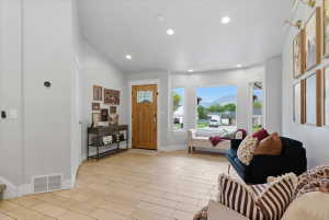 Light tile flooring extends through this room featuring a wooden entry door