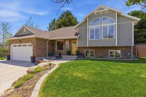 Multi-level residence featuring stone and hardie board facade, an attached garage